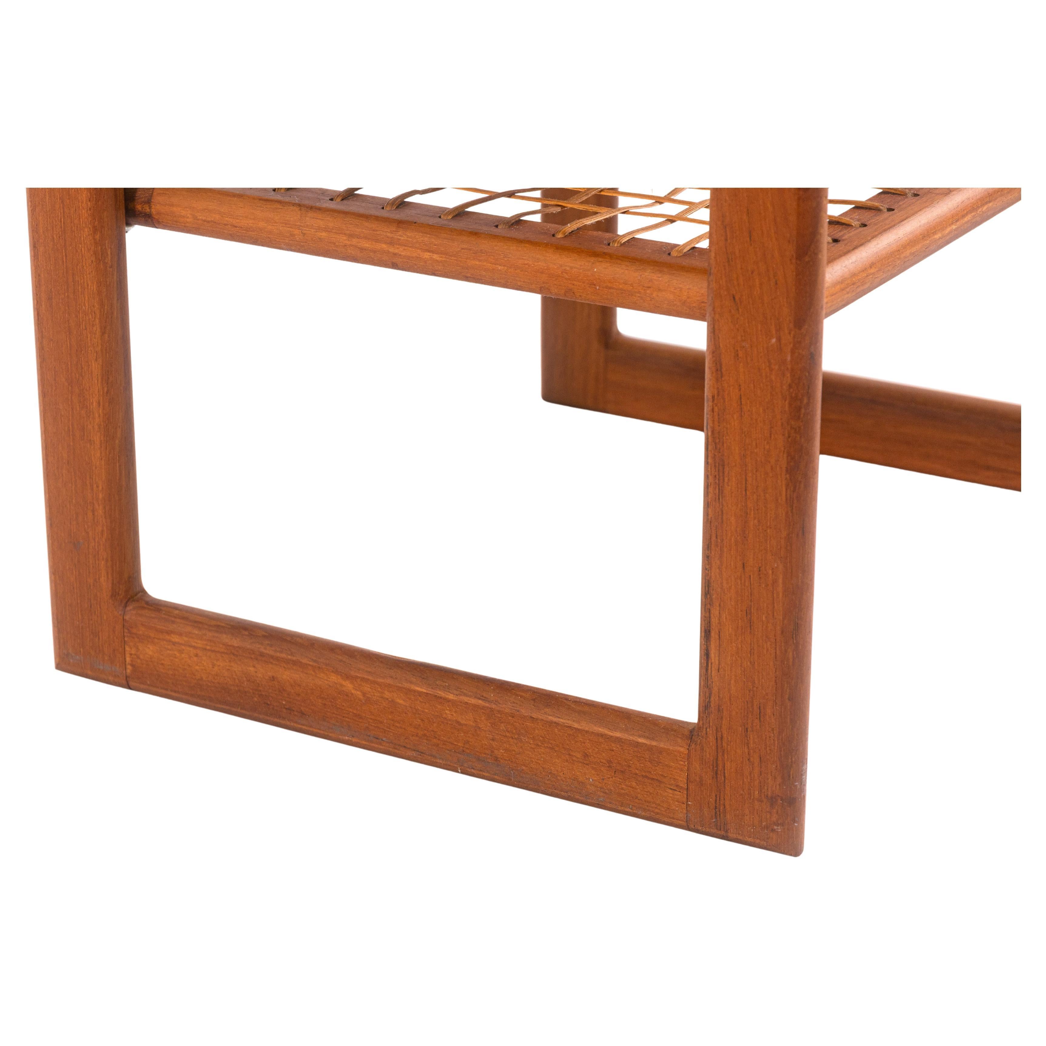 Mesa auxiliar vintage Poul Jensen para Selig. Esta preciosa mesita auxiliar moderna de mediados de siglo tiene una estructura completa de madera de teca y un segundo nivel inferior con superficie de ratán. Esta mesa auxiliar está en muy buen estado
