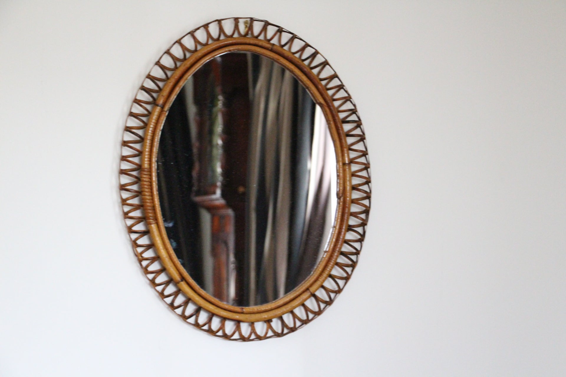 This very decorative mirror was made in Italy in 1960s. It is typical of this period design and is all original. It was handcrafted and is in perfect condition. It has got a beautiful oval shape. Moreover it could be hanged verticaly or horizontaly.
