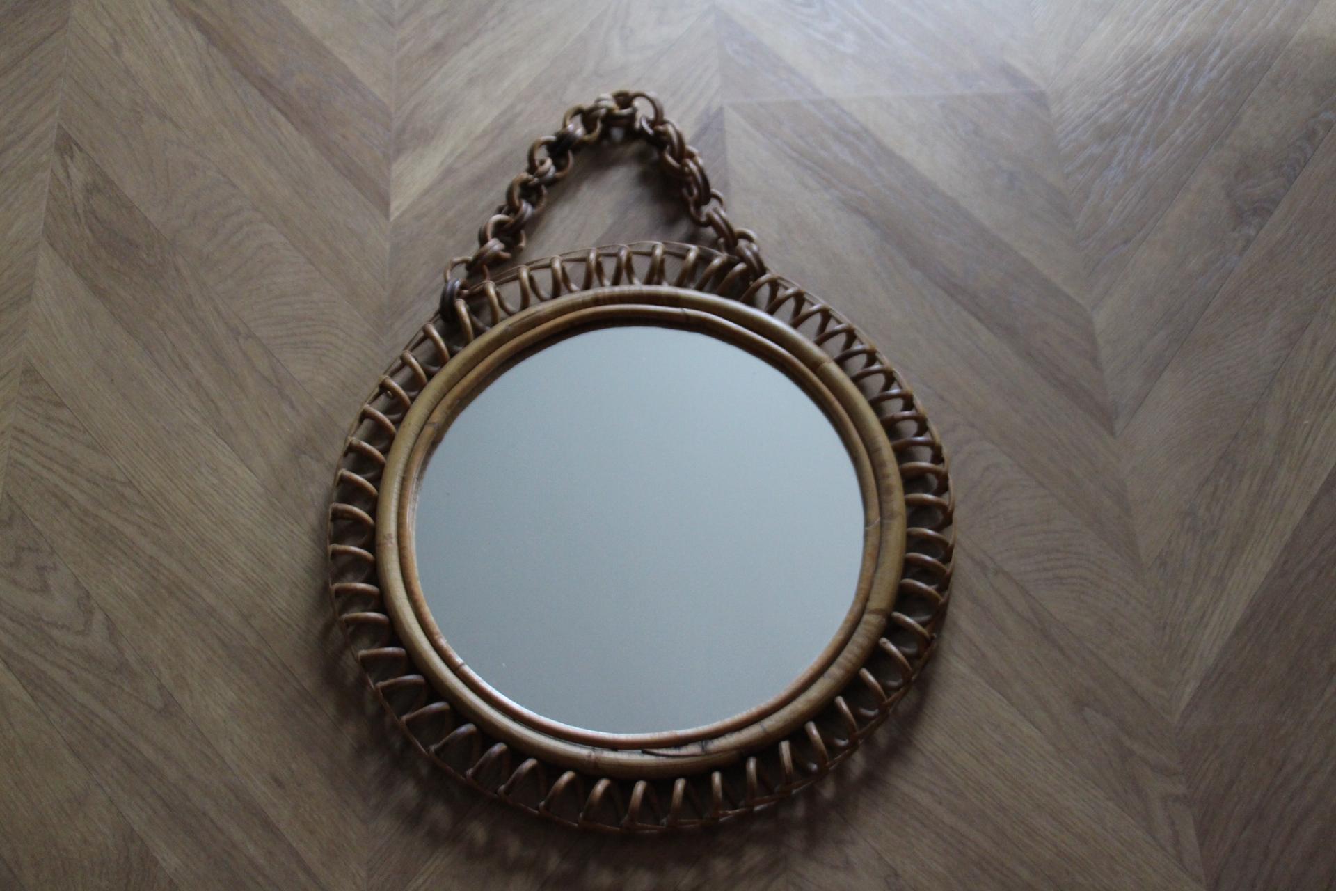 This very decorative mirror was made in Italy in 1960s. It is typical of this period design and is all original. It was handcrafted and is in perfect condition. It has got a beautiful round shape. It comes with its original matching rattan hanging