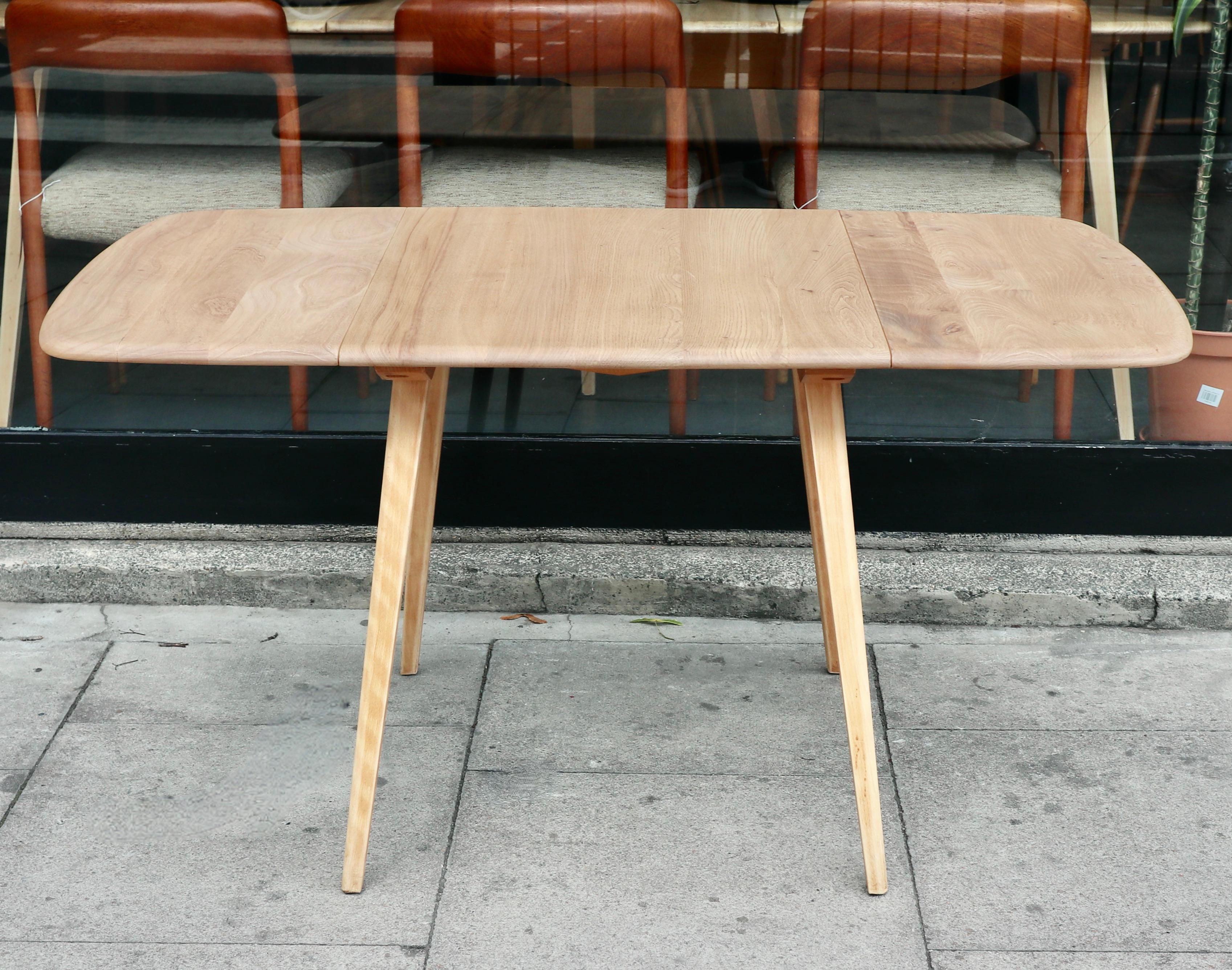 Ein rechteckiger Esstisch mit Klappe aus den 1960er Jahren von Ercol.  Dieser Tisch hat eine Platte aus massivem Ulmenholz und ein vierbeiniges Untergestell aus massiver Buche. Er hat zwei Klapptische und ist in einem sehr guten Vintage-Zustand, da