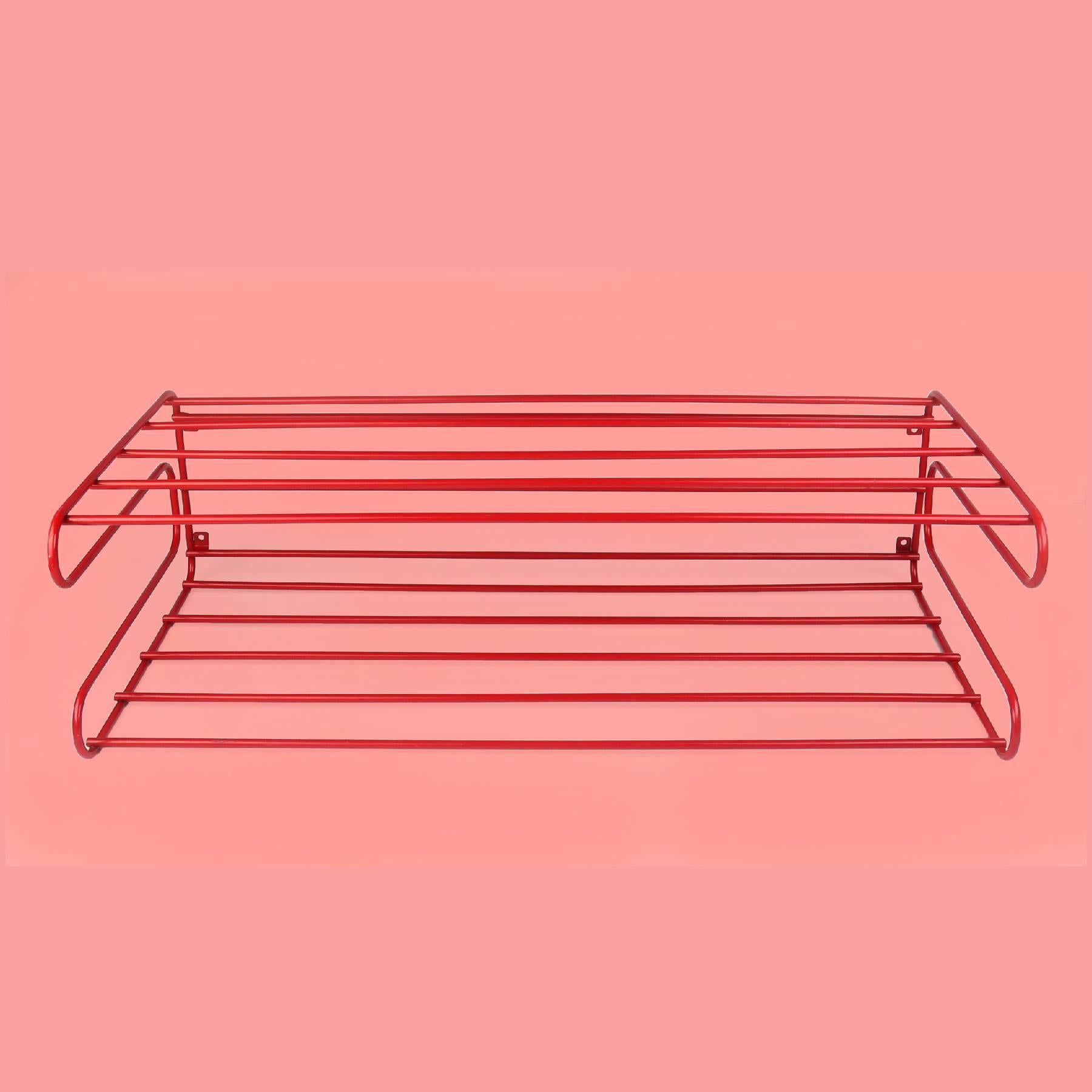 A perfect Mid-Century Modern red coated metal wire shelf or rack. In the style of Tomado or Pilastro, this piece is in perfect vintage condition with the original mounting hardware. (Mounts to the wall with four screws or anchors.) Can be used with