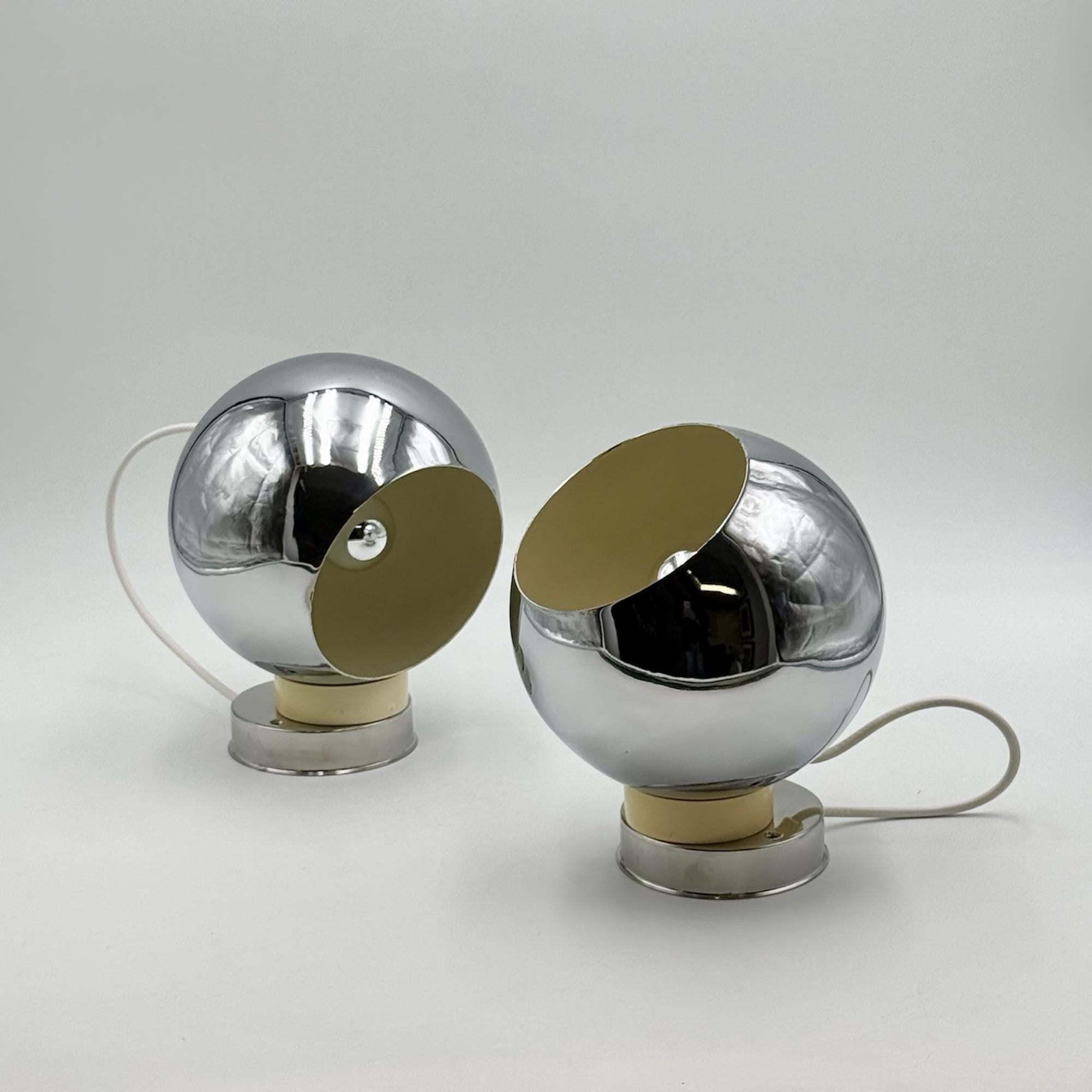 rare pair of Reggiani lamps. Featuring chrome-plated metal globes and an innovative magnetic base, these adjustable wall or ceiling lamps offer both sculptural beauty and functional brilliance. This pair is made of two large models (18 x 16 x 22