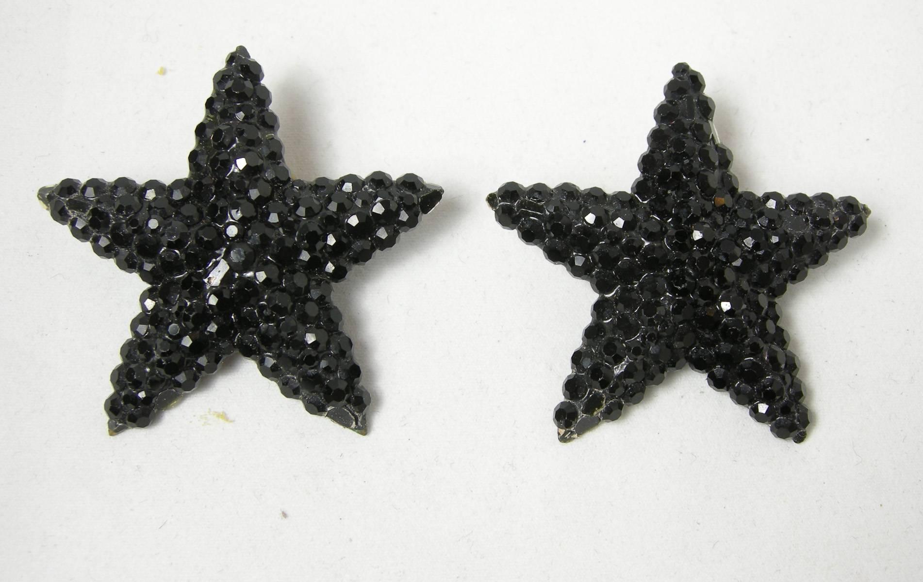 These clip earrings are made by Richard Kerr.  His workmanship is exceptional.  They are black rhinestone in a 5 pointed star design.  They are 2” in diameter.  The back is black enamel with a gold tone clip back.  It is signed “Richard Kerr”. 