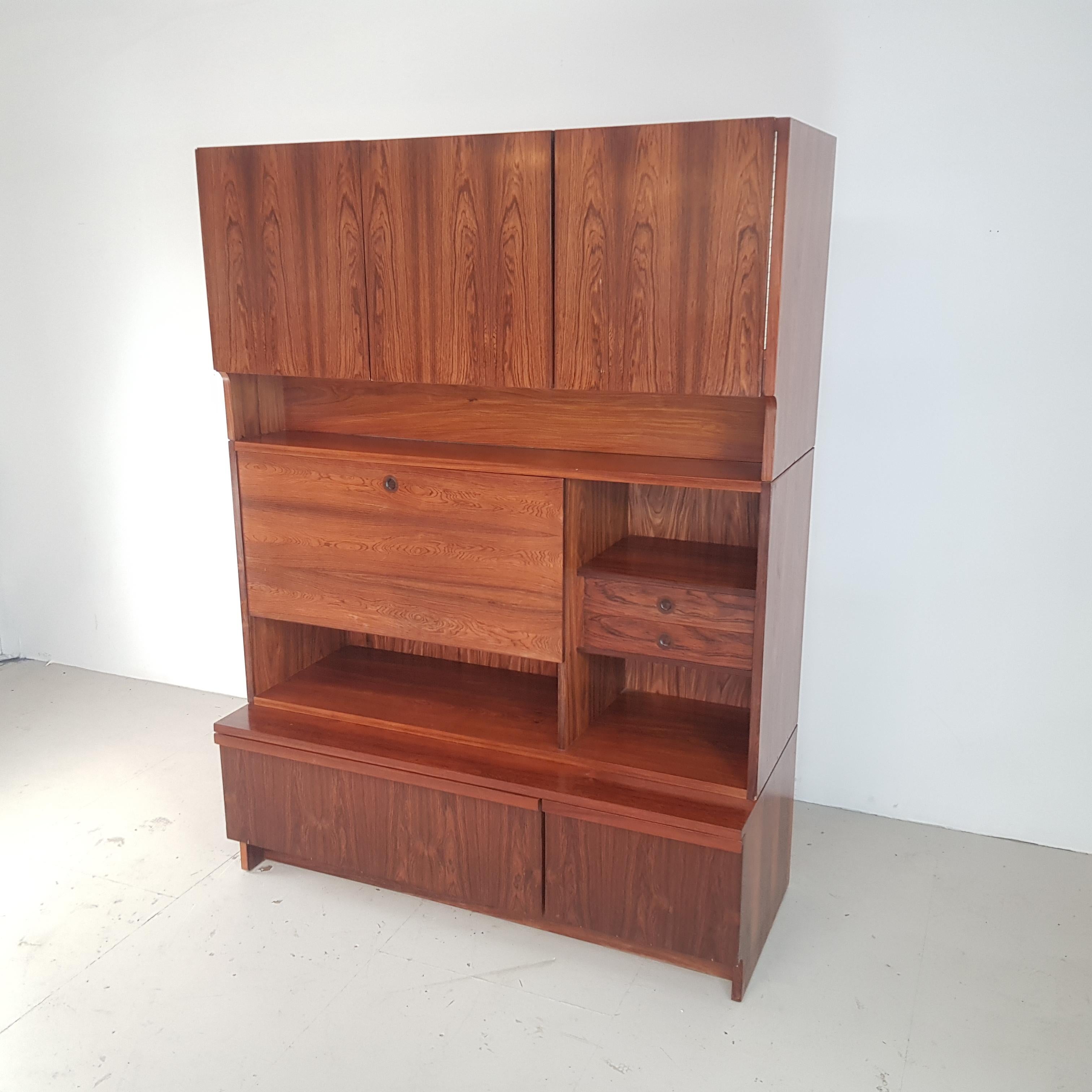 Fantastic rosewood wall unit sold in Heals by Robert Heritage for Archie Shine.
Designed by Robert Heritage in 1957 and produced by Archie Shine this large sideboard or wall unit has 3 doors along plus multiple drawers and sliding or folding down