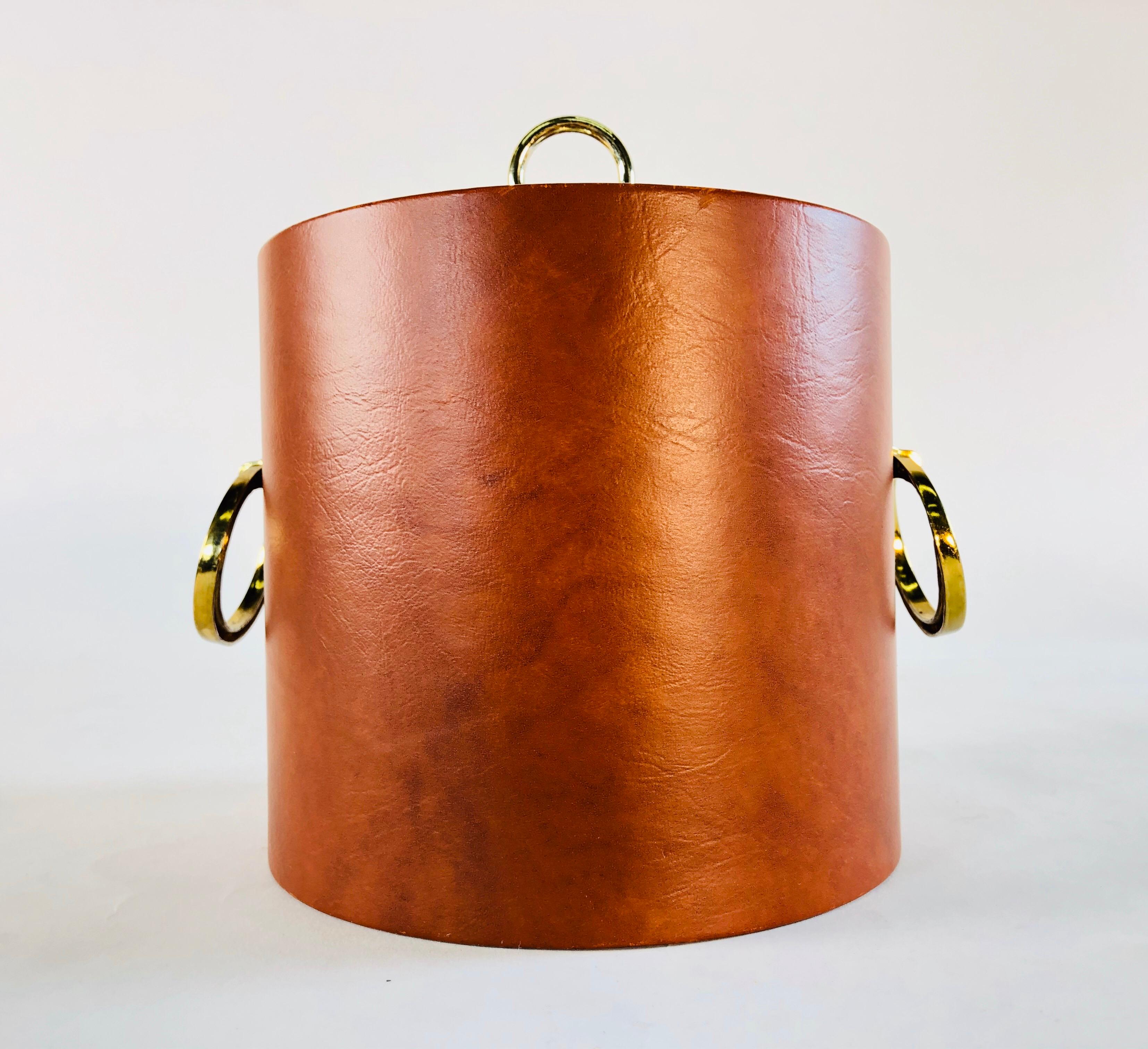 Vintage 1960s rust vinyl and gold metal accented round ice bucket. Very good condition. No marks.
