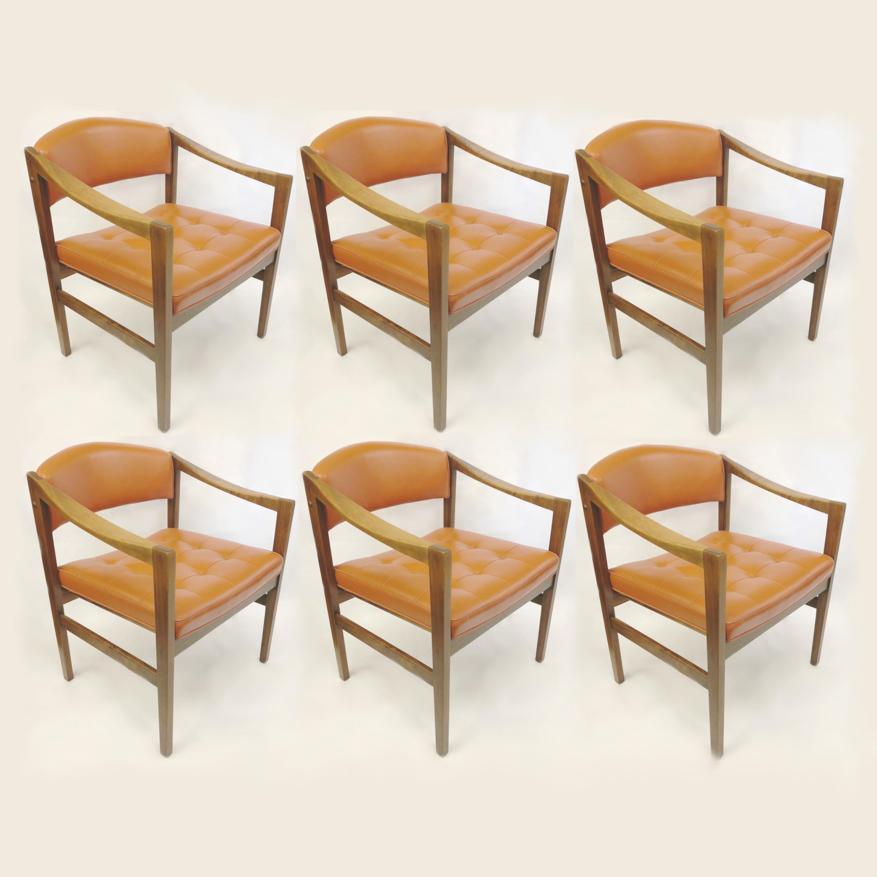 Wonderful set of midcentury dining/office chairs by the Monarch furniture Company. Chairs feature beautifully sculpted, downward swooping arms, original tufted, burnt-orange vinyl, and solid walnut frames. These chairs sit as good as they look and