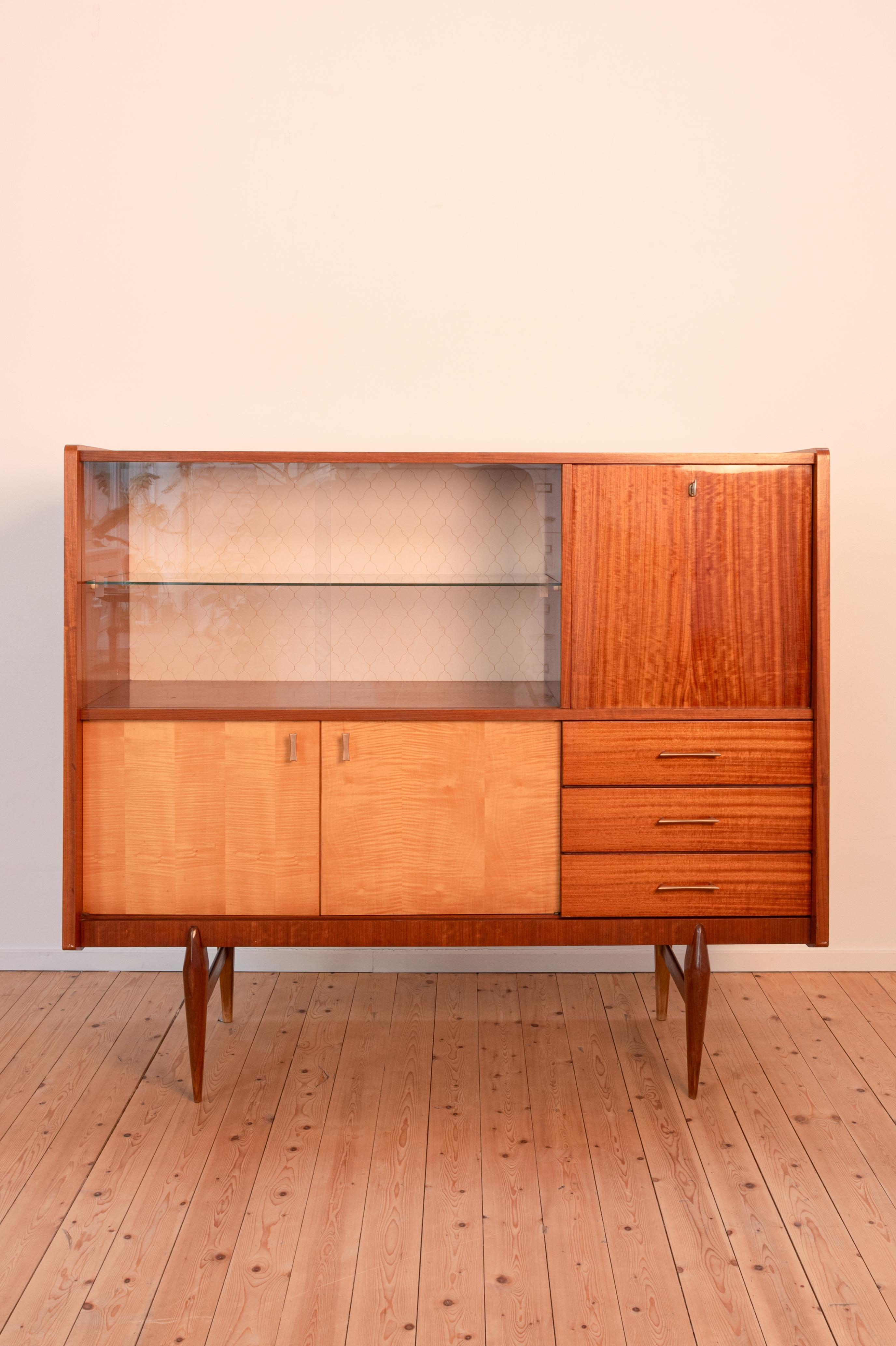 This vintage sideboard from the 60s has 3 drawers, a display shelf in glass, and 3 additional compartments. In excellent condition. 