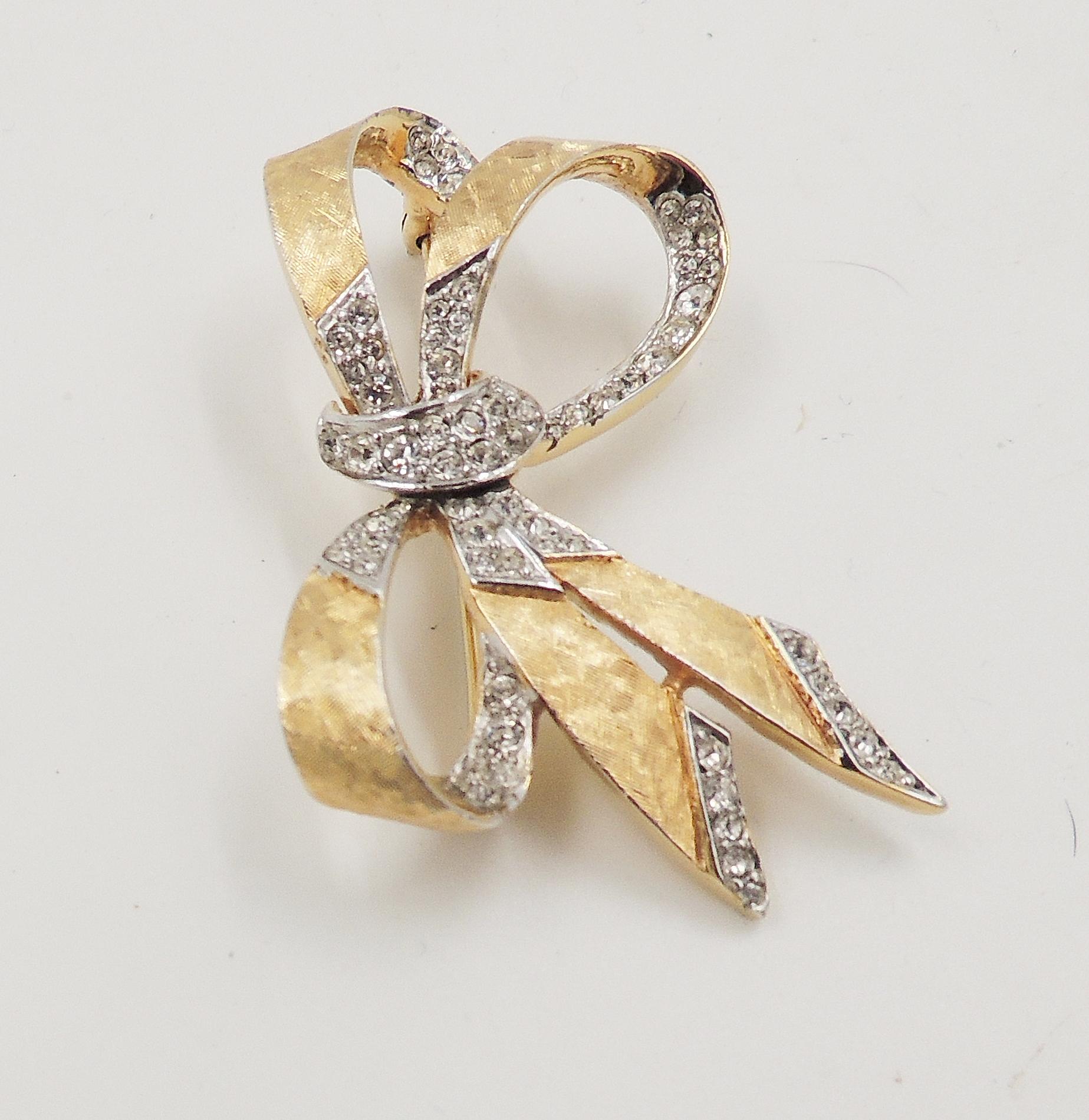 Late 1960s textured goldtone and clear rhinestone brooch with security clasp. Marked 