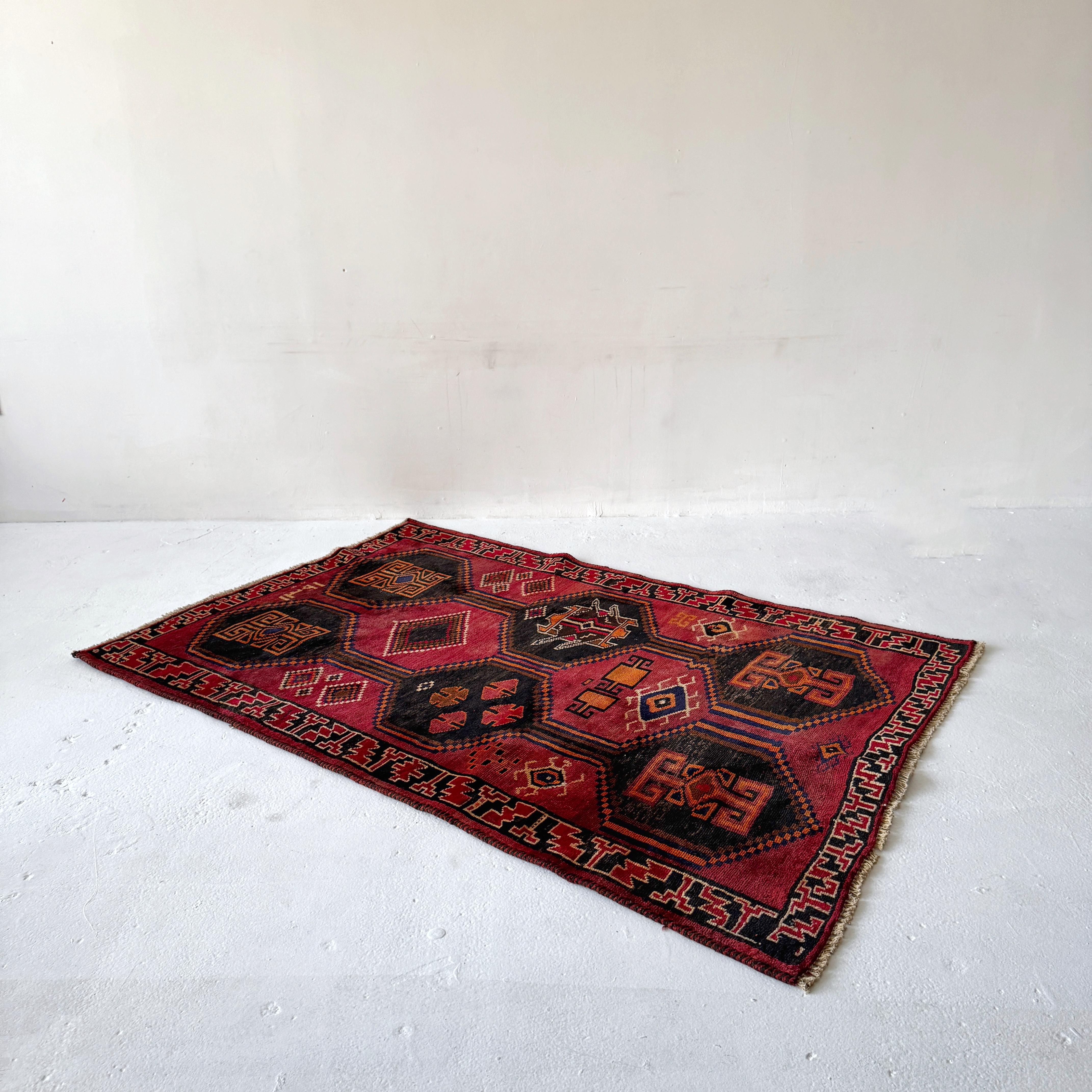 Tappeto caucasico vintage degli anni '60 firmato in nero, rosso e arancione
Un sorprendente tappeto caucasico tessuto a mano della metà del XX secolo, firmato dal tessitore. Presenta un audace motivo a medaglione esagonale a nido d'ape nei ricchi