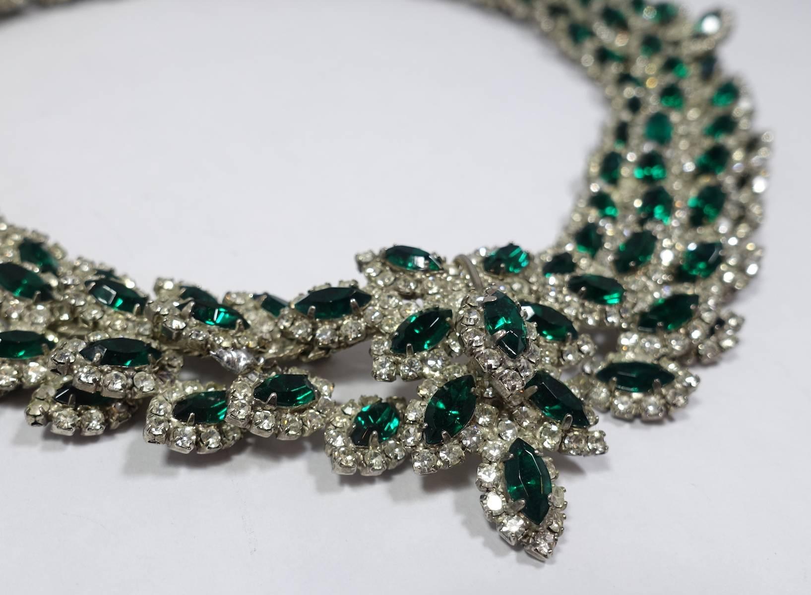 This vintage 1960s Les Bernard necklace features green and clear crystals in a silver tone setting.  The necklace measures 15-1/2” long with a slide in clasp.  The centerpiece has a 3-dimensional design and measures 1-1/2” wide.  This vintage
