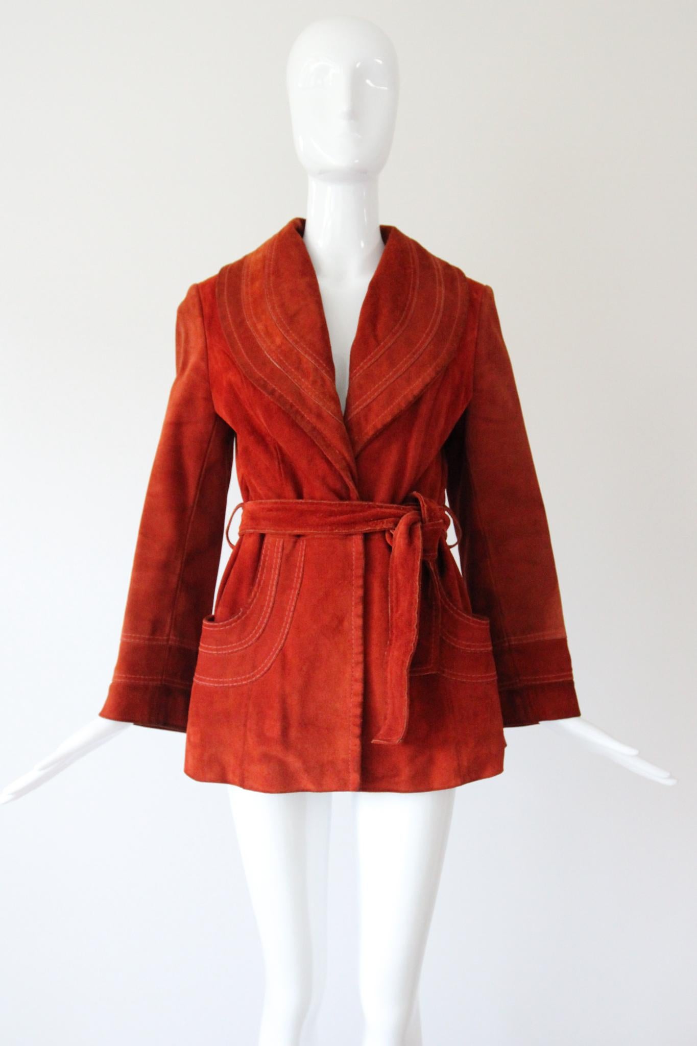Rendered in the warmest shade of burnt Sienna suede, this original vintage 1960's coat, is just the piece to welcome the cooler seasons with.
The V shaped neckline is framed by a rounded shawl collar, which showcases three tiers of suede sewn in a