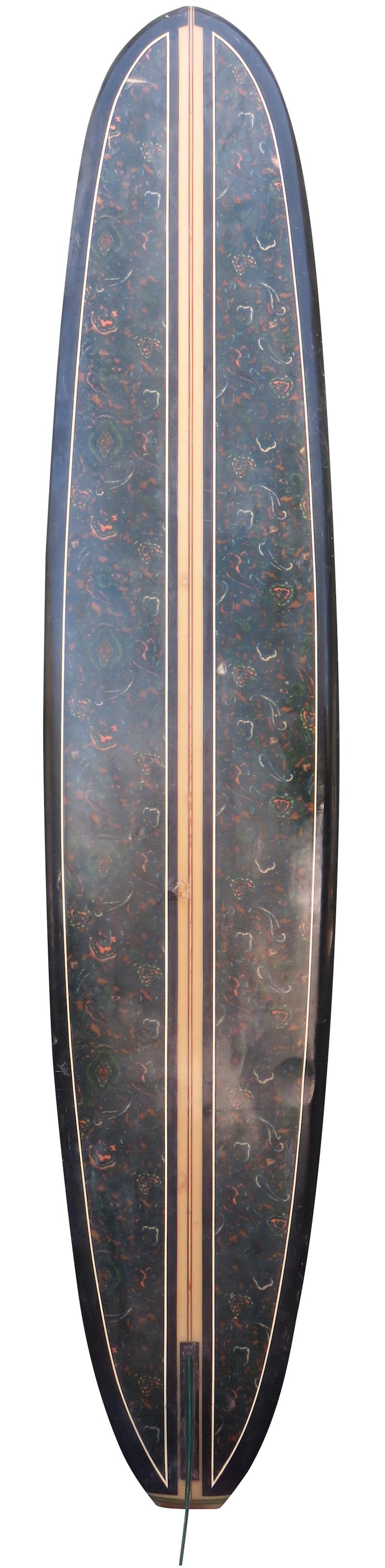 Late 1960s tamarack longboard surfboard. Features a balsa and redwood T-band stringer design with black rails and dark paisley pattern on bottom of board. A great example of a late 1960s vintage longboard surfboard made in California.