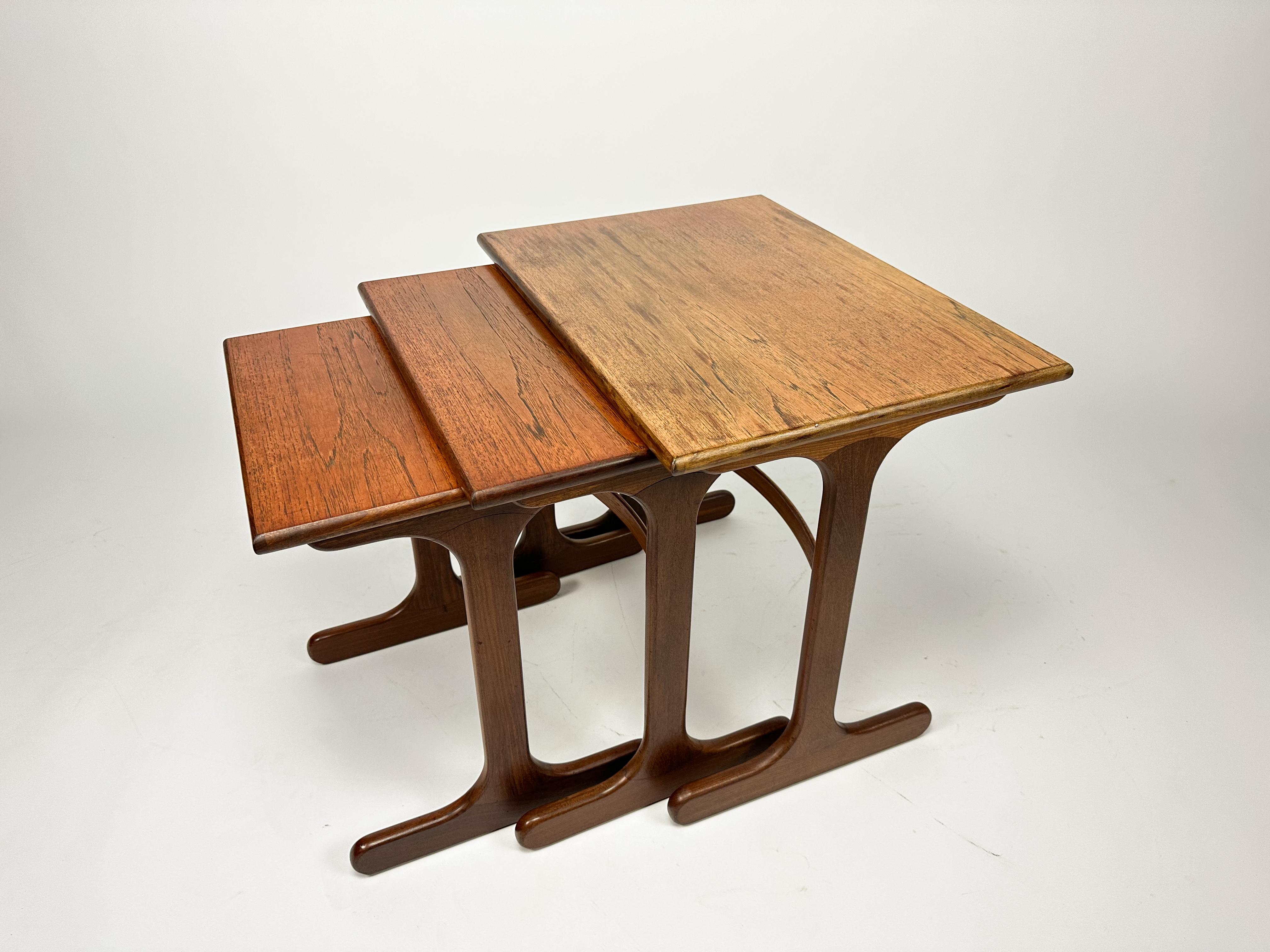 Nido di tavoli G-Plan in teak della metà del XX secolo, circa 1960. Il nido ha piani rettangolari sollevati su supporti a coda di balena. Misura circa 52 cm x 56 cm x 40 cm (20,5