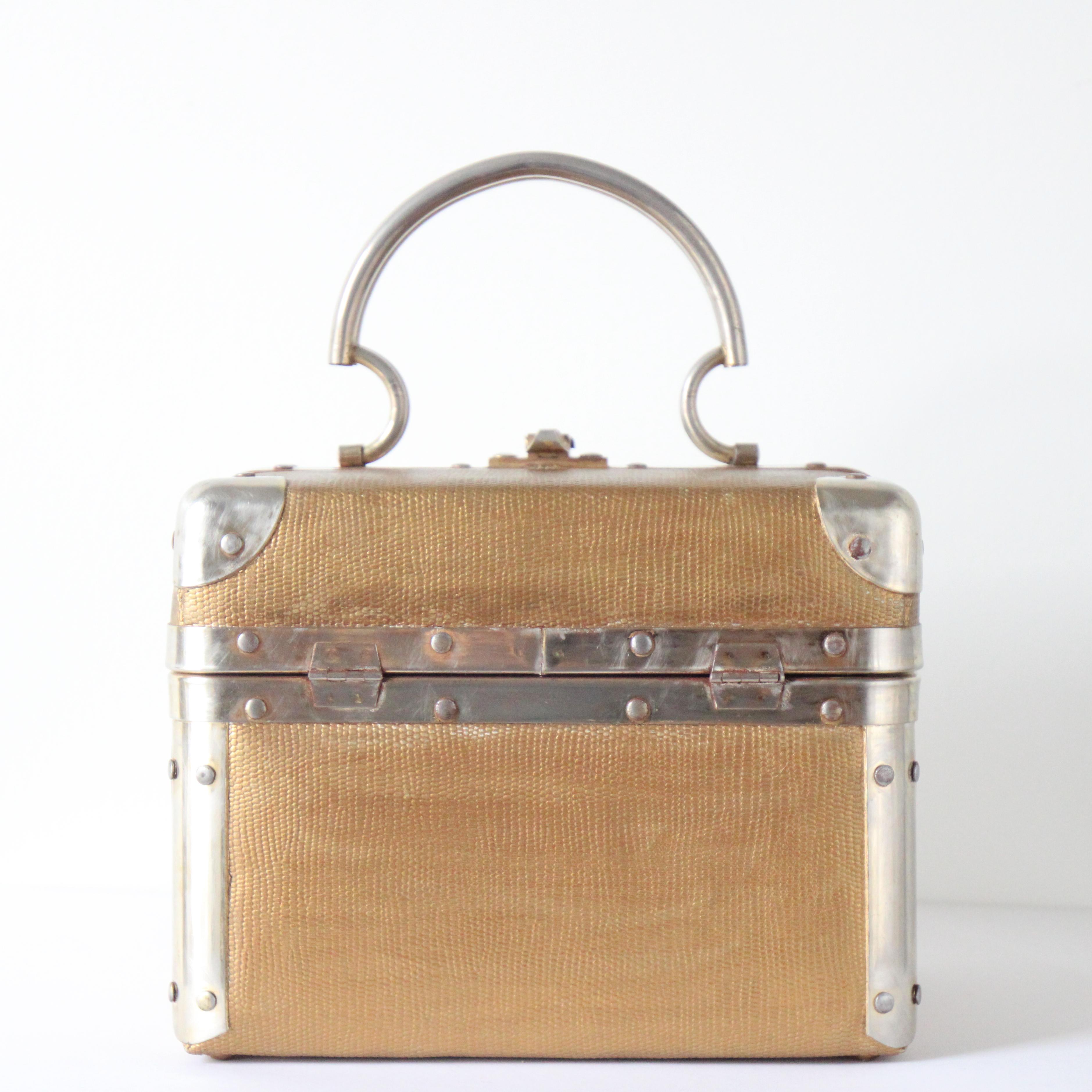 This beautiful textured gold painted vinyl and silver hardware box bag, is the perfect statement vintage piece to complete your outfit. 

The beautiful box shape of the bag is accented by silver toned metal hardware with stud details and a matching