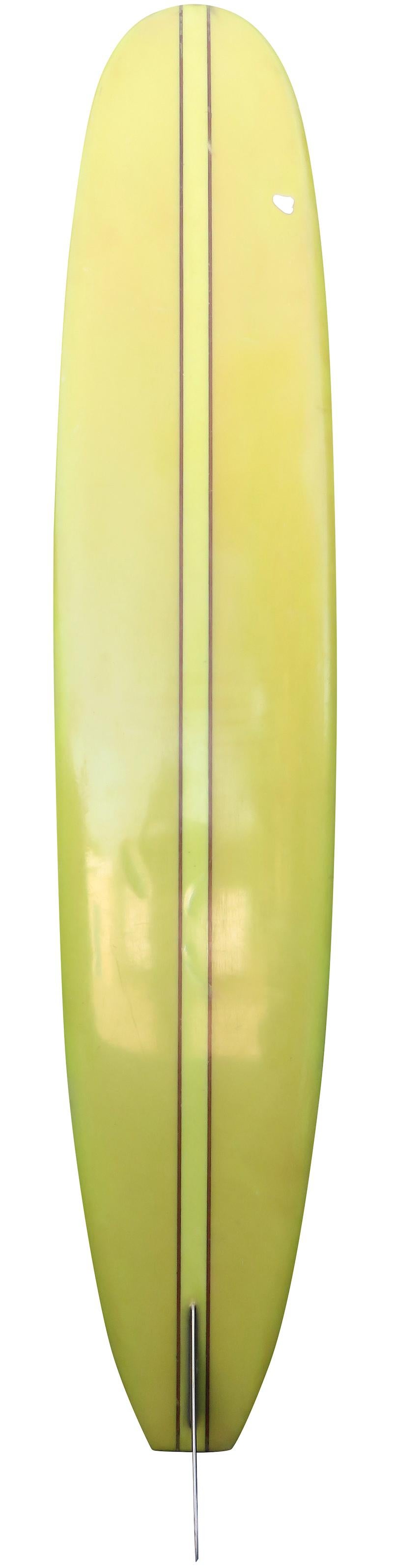 Mid 1960s “The Personal” longboard by South Coast. Features a redwood double stringer design, lime green tinted rails and bottom, and black fin with white halo. A great example of a 1960s classic longboard. This vintage surfboard remains in all