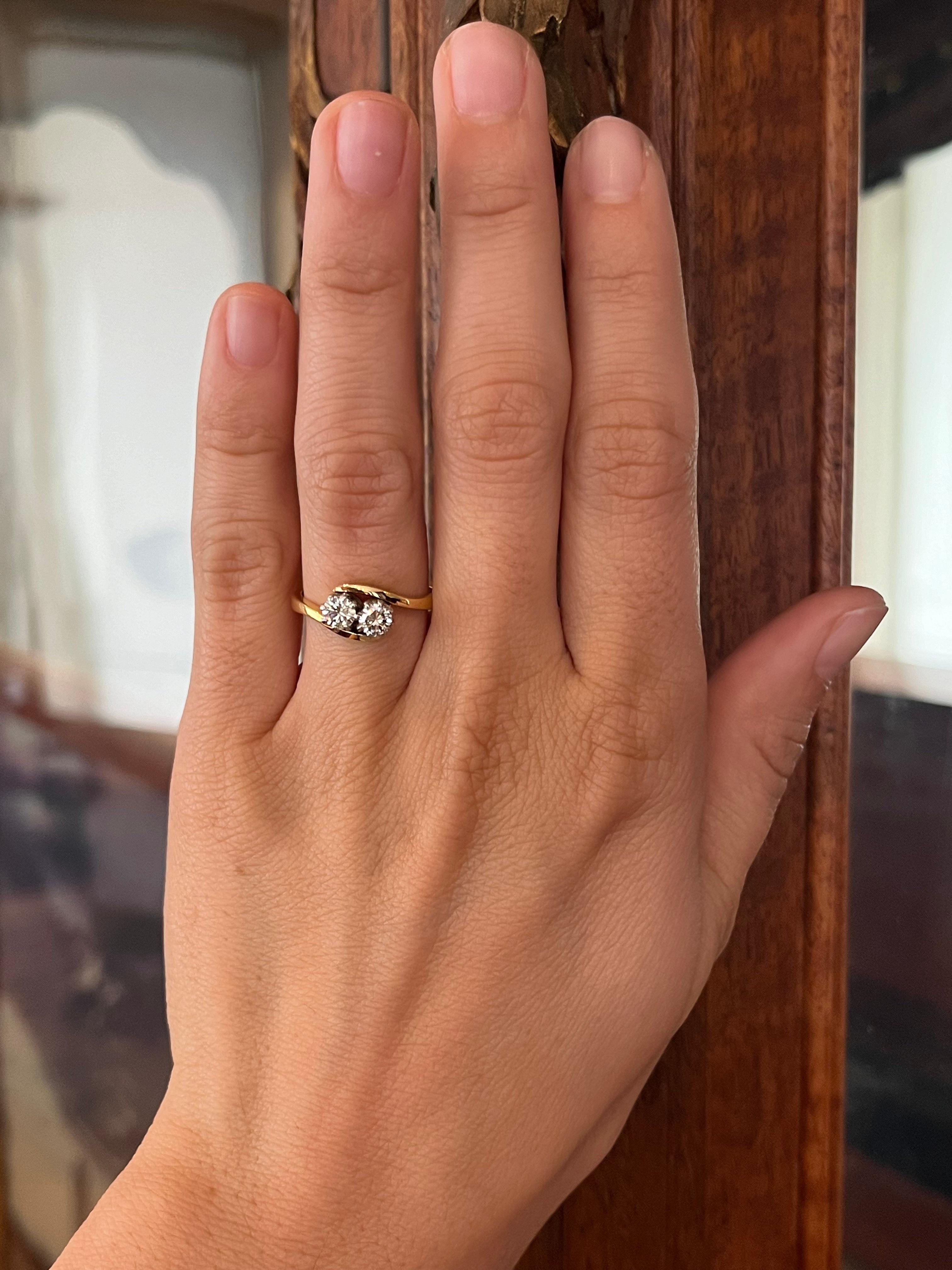 Circa 1960s, this Toi et Moi ring pairs two round diamonds—0.27ct and 0.26ct—both VS1 clarity, H color. Crafted in 18K yellow gold with platinum heads, this romantic duet speaks of mid-century elegance. Made in England.

- Circa 1960s
- One 0.27ct