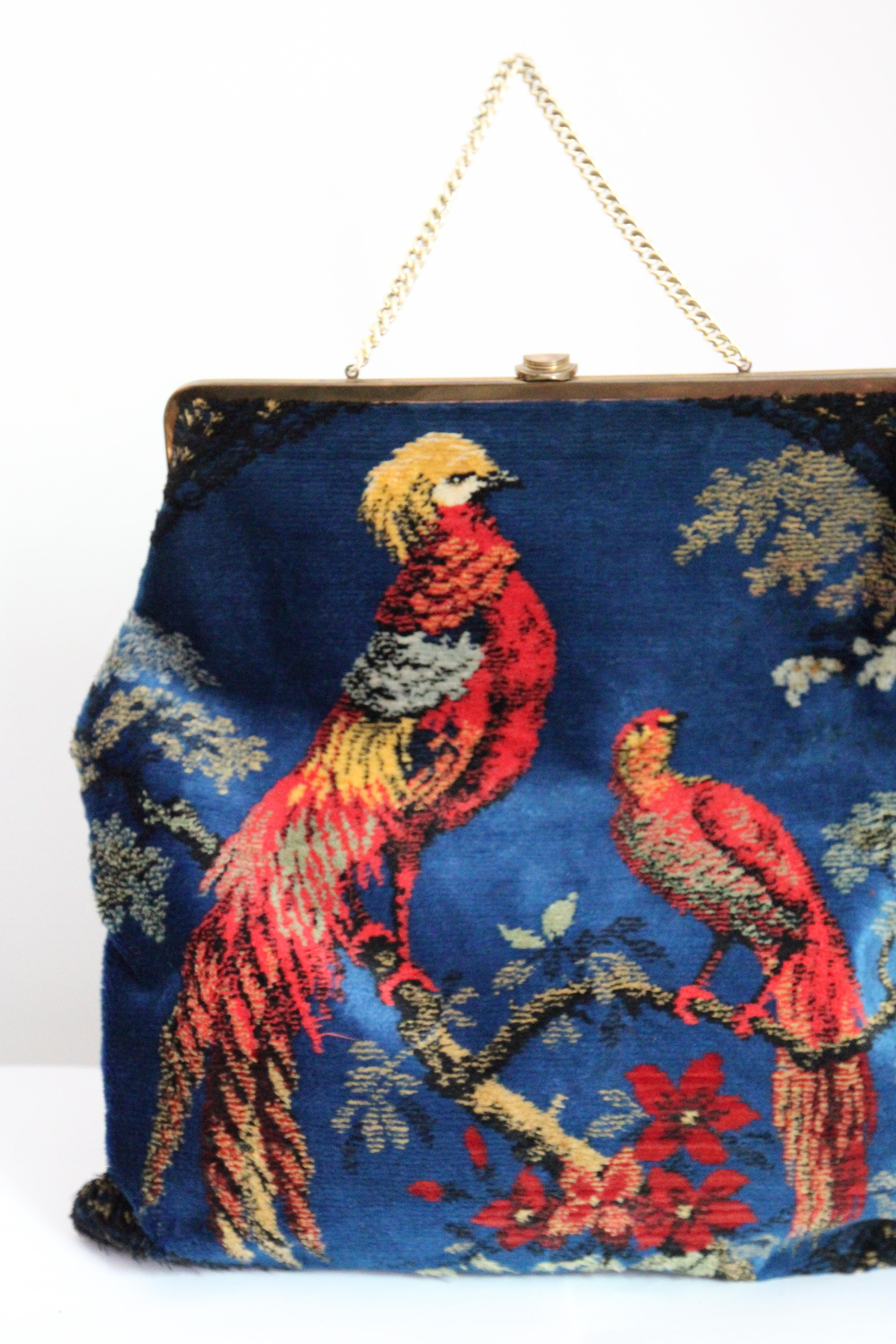 Diese wahrhaft prächtige große Samthandtasche aus den frühen 1960er Jahren ist in einem göttlichen Farbton von tiefem Azulblau und reichen Juwelenfarben gehalten und zeigt zwei rote Vögel, die von üppigem Laub und Blumen umgeben sind,  ist ein