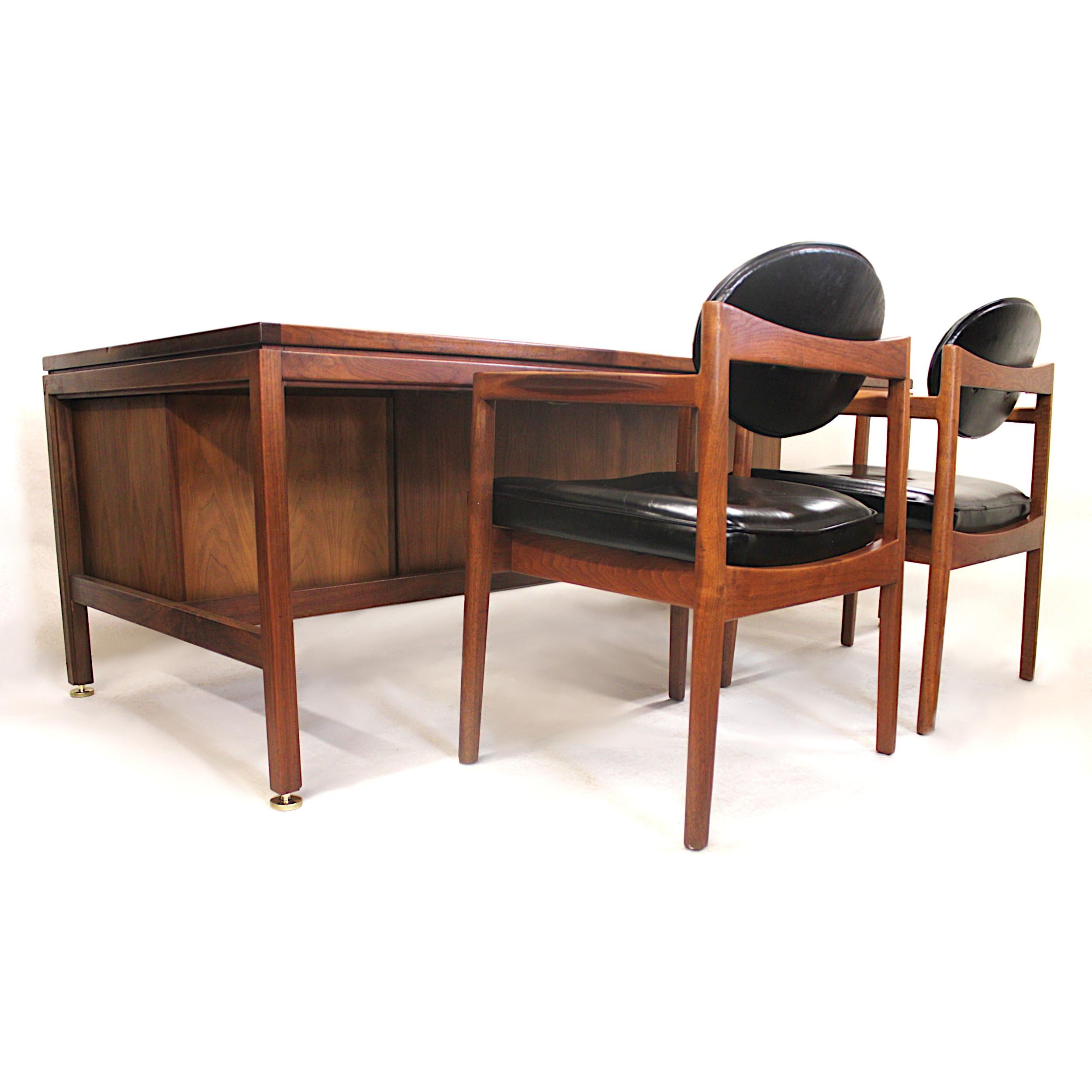 This wonderful office set by Jens Risom includes an imposing yet inviting executive desk and two matching guest chairs. The desk is in excellent original condition and includes many interesting details including; dual locking cabinets, solid brass