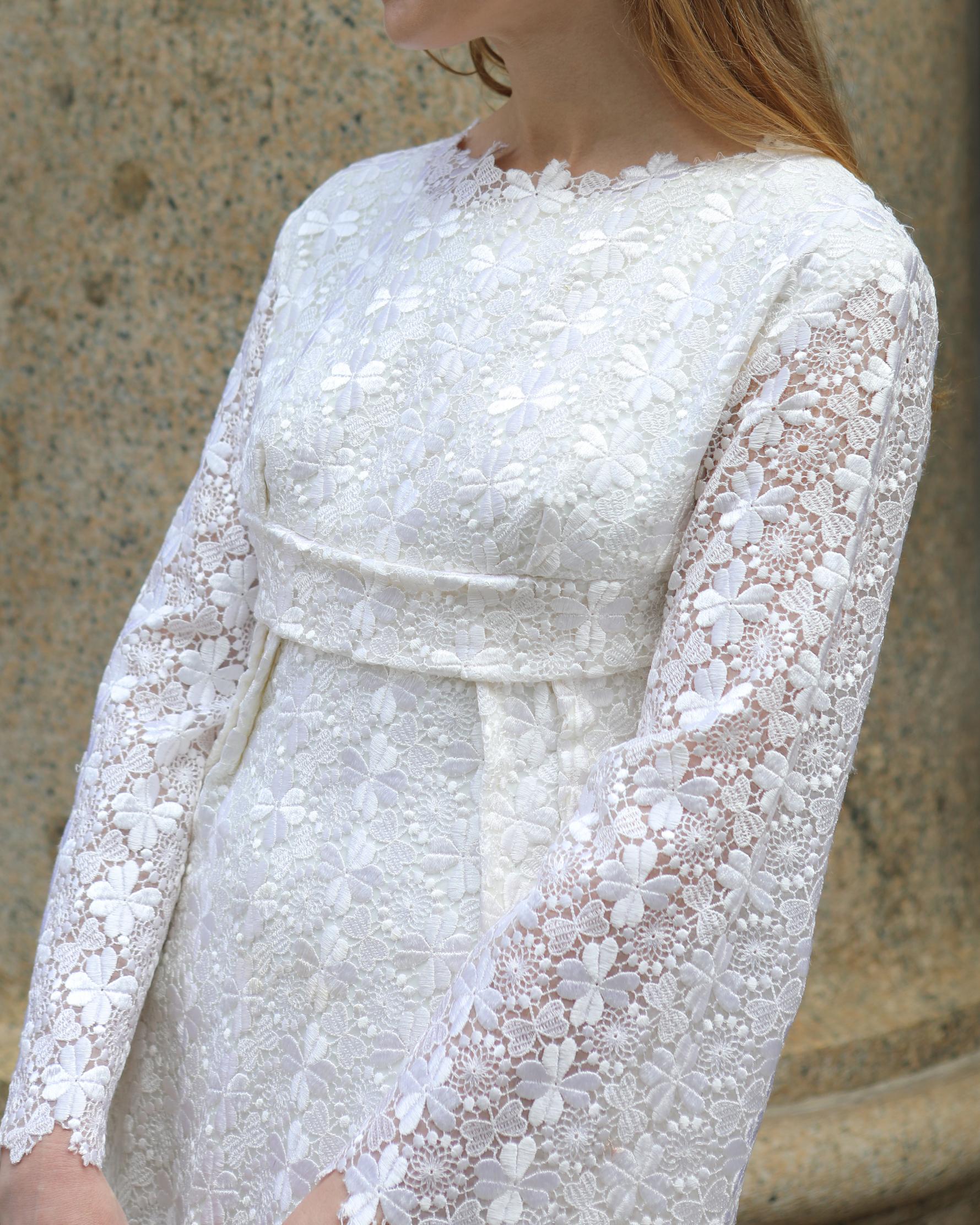 Dieses wunderschöne weiße Spitzenkleid aus den 1960er Jahren hat eine einzigartige Empire-Taille und Glockenärmel mit Wellenkanten. Dieses Kleid wurde nach Maß angefertigt und ist einzigartig - es ist eine fantastische Vintage-Brautausstattung für