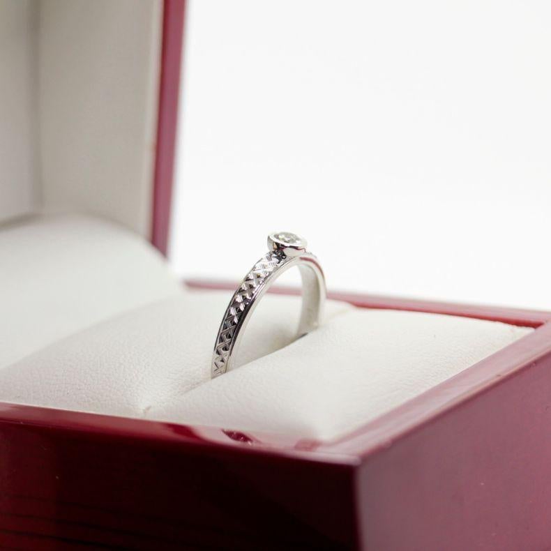 Newly Restored, 1960's White Gold Solitaire Engagement Ring, with Engraved Shank
14ct White Gold Solitaire Ring, narrow, flat, tapered patterned shank bezel setting, polished finish.
The ring contains:
One rub over set round brilliant cut diamond,
