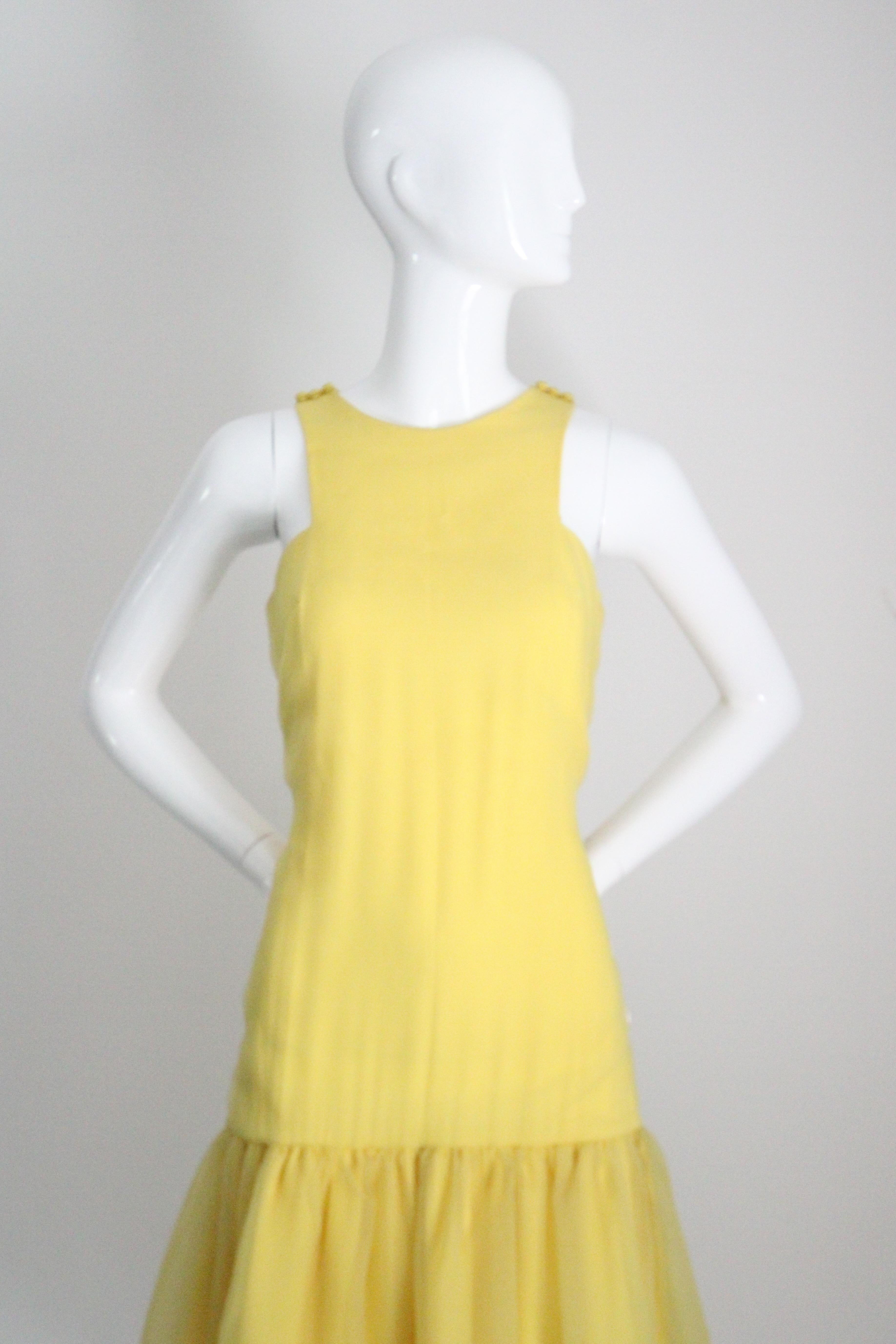 Cette robe vintage originale à taille tombante des années 1960, d'un jaune soleil des plus éclatants, est la pièce parfaite à ajouter à votre collection saisonnière. 

L'élégante encolure arrondie est encadrée par des bretelles simples qui se