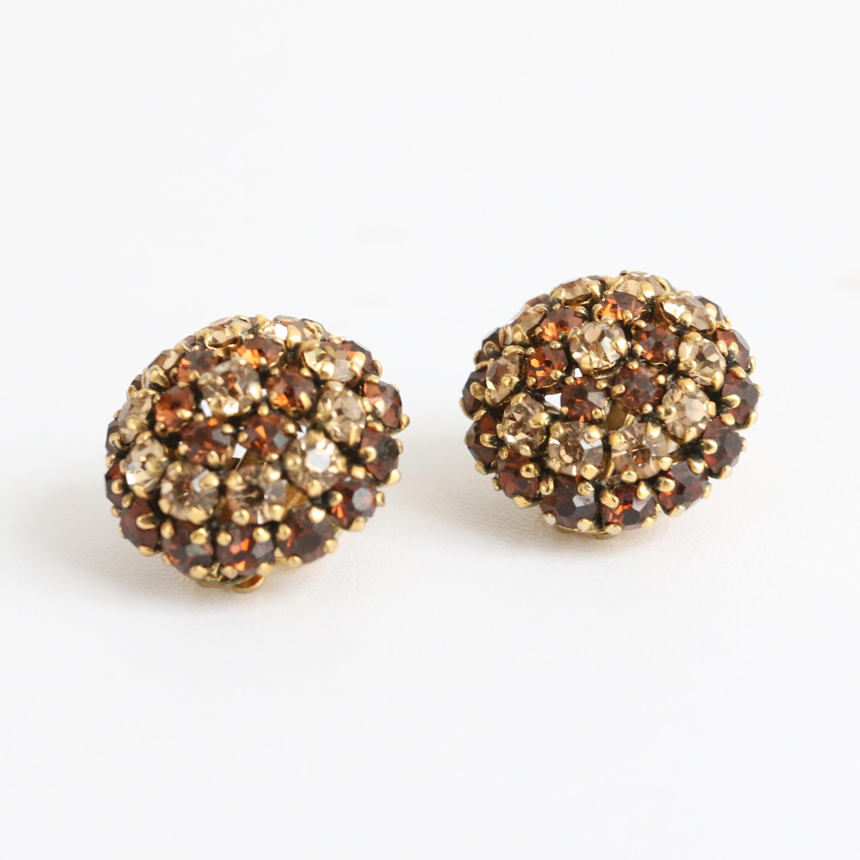 This wonderful pair of 1960's clip on earrings, by Christian Dior are a rare set to behold.
Made up of claw set glass rhinestones in Champagne tones and bronze in an alternating striped pattern in a domed design, these dazzling earrings are the