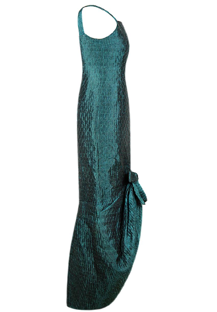 CHRISTIAN DIOR

Rare vintage Christian Dior haute couture gown of 1960s in textured emerald coloured silk on a delicate silk lining.

 Slim feminine silhouette, full hem decorated with a bow. 

Centre back seam zipper fastening. 

Outstanding piece,