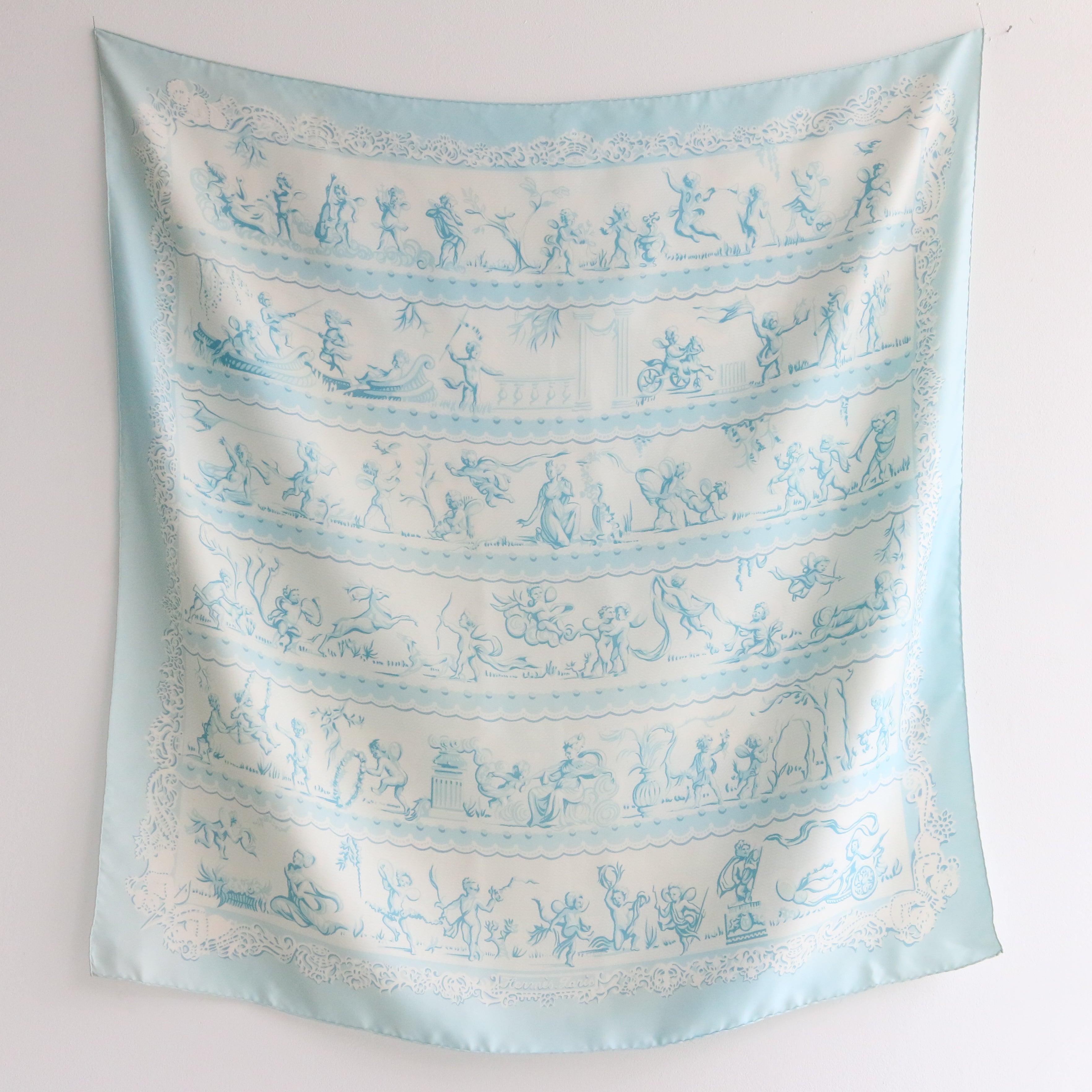 This rare 1960's silk Hermès scarf, designed by Françoise Héron is the perfect finishing touch to any outfit.

In a soft shade of ice blue and turquoise, with a pattern of cherubs playing in rows, with goddesses, greyhounds and stags, this divine