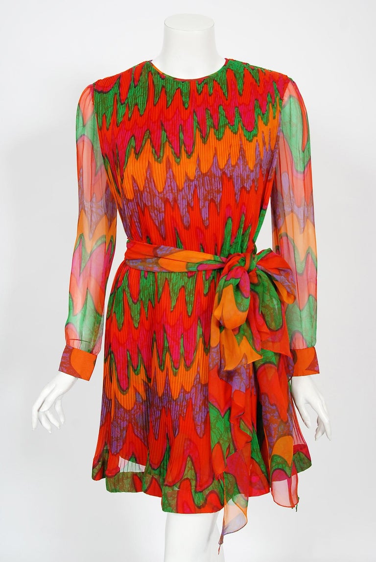 Spectacular late 1960's Pierre Cardin pleated silk chiffon babydoll mini dress in a vibrant psychedelic print. In 1951 Cardin opened his own couture house and by 1957, he started a ready-to-wear line; a bold move for a French couturier at the time.