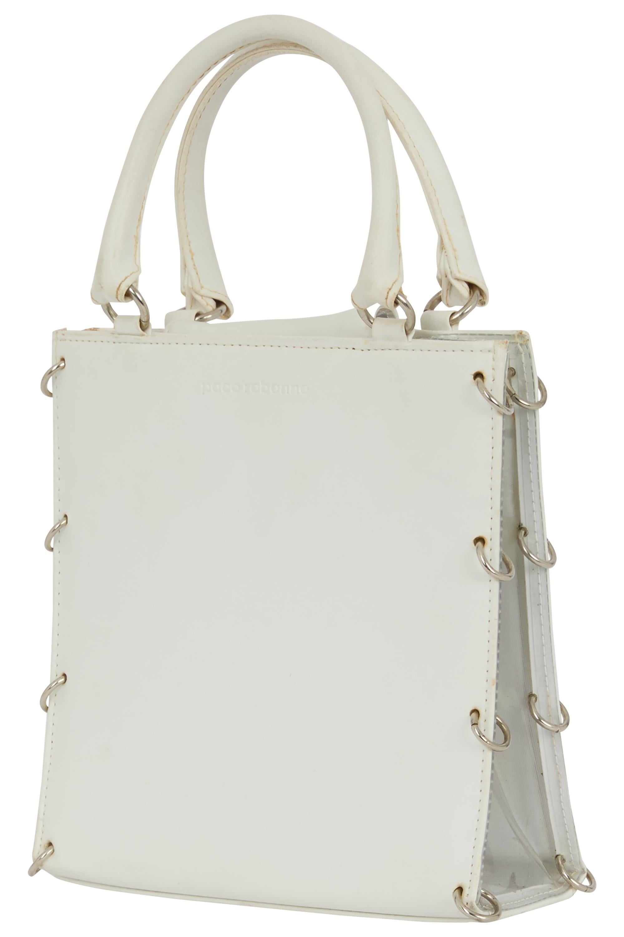 Sac à main vintage Paco 1969 Paco Rabanne en cuir blanc avec des arceaux en acrylique et en acier inoxydable. Ce fourre-tout en cuir blanc réimagine le minimalisme à travers une lentille sculpturale, presque industrielle. La silhouette rectangulaire