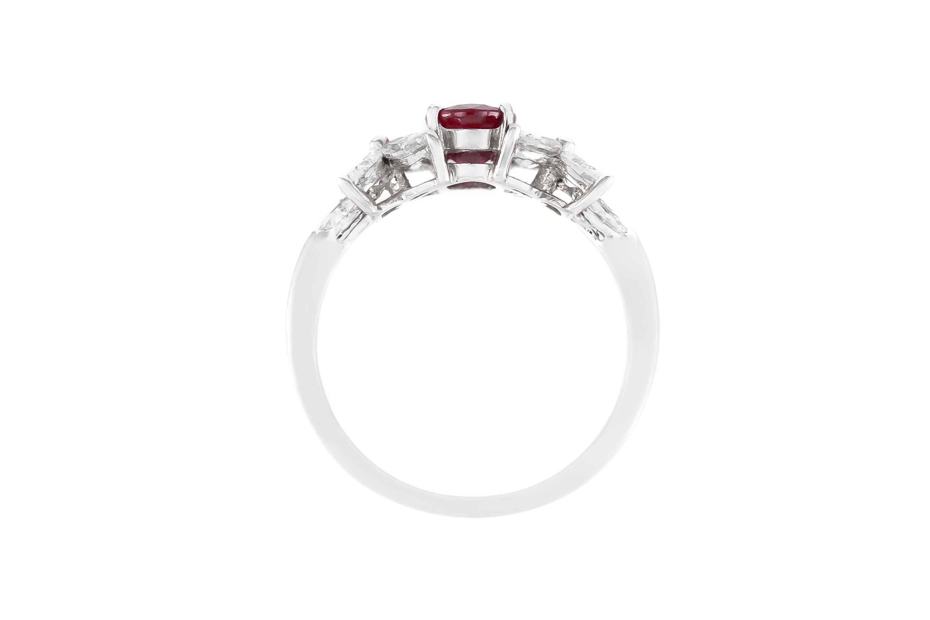 Fein gearbeitet in 18 Karat Weißgold mit einem Rubin im Ovalschliff mit einem Gewicht von 0,93 Karat, akzentuiert durch 4 Diamanten im Marquise-Schliff, die in einem Blumenmotiv auf jeder Seite angeordnet sind, mit einem Gesamtgewicht von 1,06