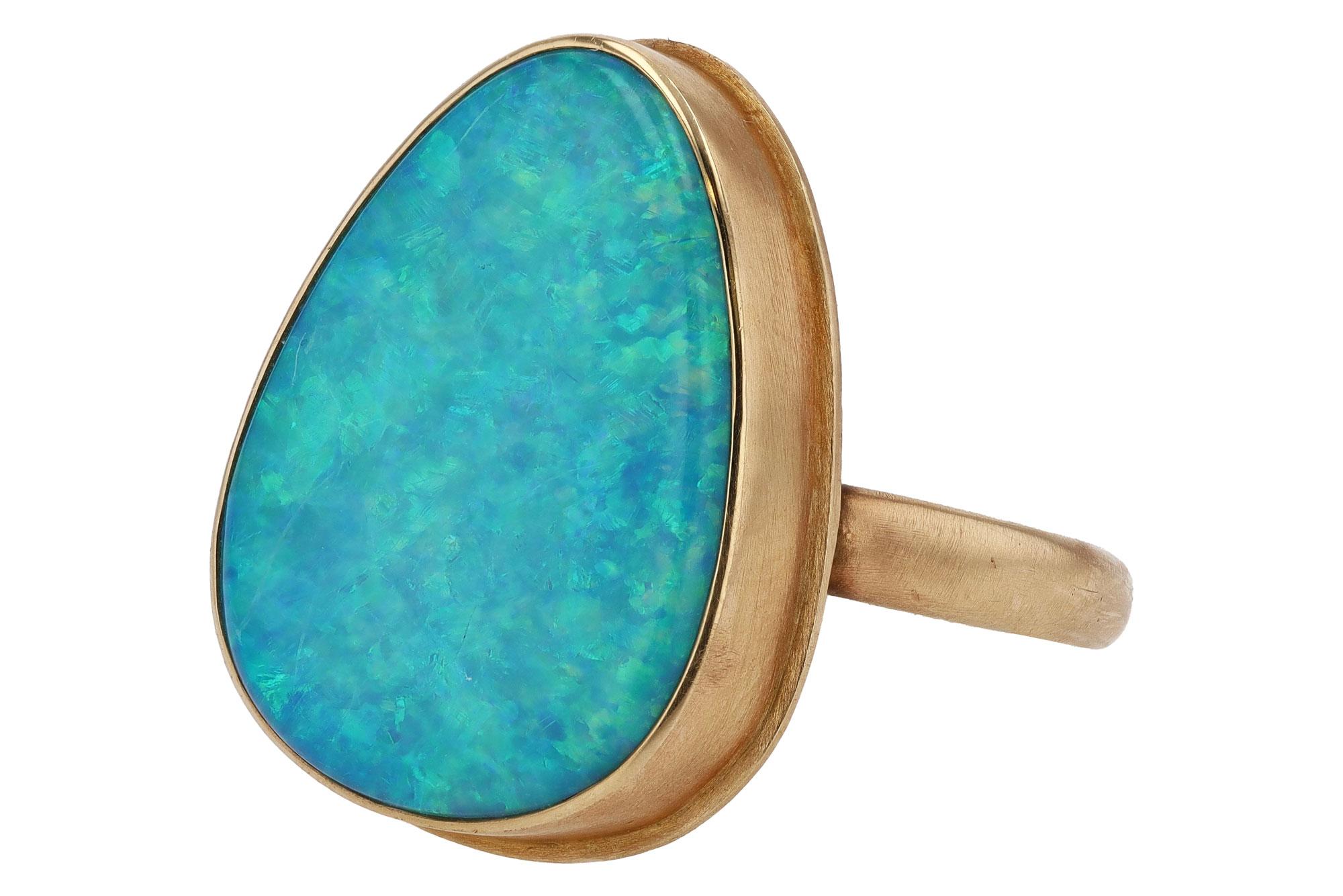 Own a piece of history with this vintage 1970s cocktail ring. The center Australian fire opal weighs 10 carats with prominent play of color. Crafted in 14k yellow gold throughout, this sustainable and ethical jewel is a fantastic value that will be