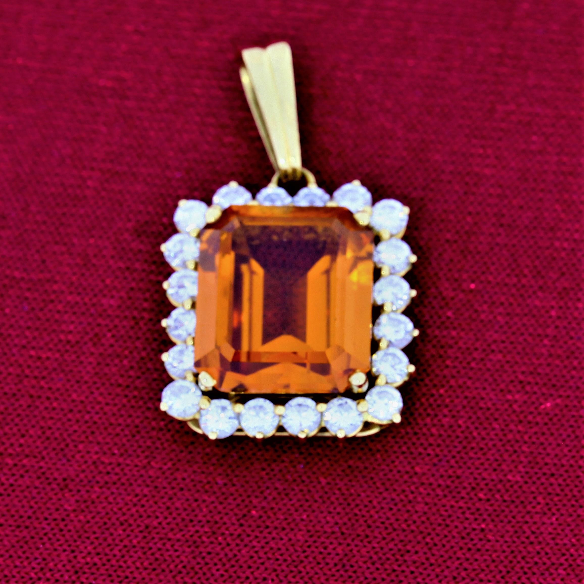 This 1970s vintage orange sapphire pendant is stamped 750 for 18 karat gold. The sapphire weighs approximately 10 carats, orange of medium strong saturation, with good transparency and minor abrasions. Diamonds bright and lively. Sapphire weighs