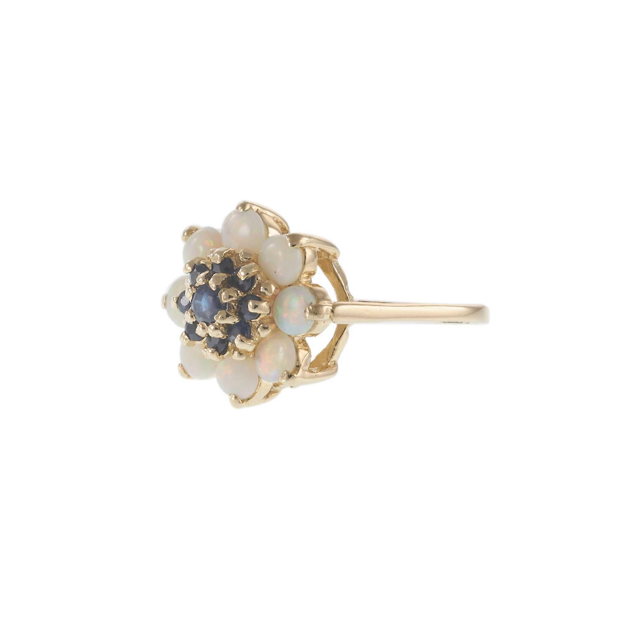 Un tesoro radioso degli anni '70, questo anello vintage cattura l'eleganza senza tempo in un grappolo di ispirazione floreale. Realizzato in oro giallo 14KT, il design presenta un vibrante centro di circa 0,50 carati di peso totale di ricchi zaffiri