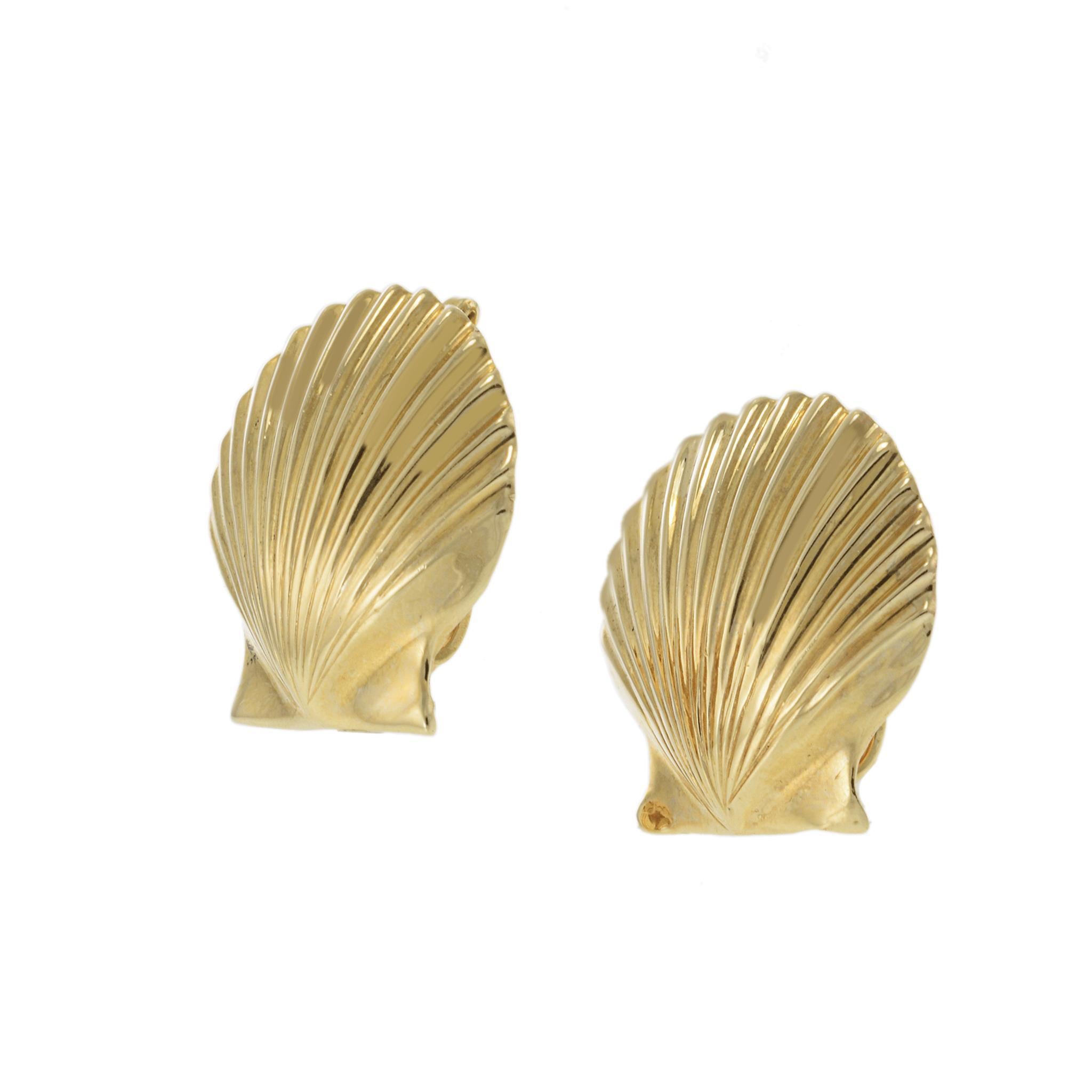 Elegant 1970 14K Yellow Gold Scallop Shell Earrings. This exquisite pair of earrings is crafted in 14k yellow gold. The earrings feature a detailed shell design with a polished finish. They are in excellent condition and have a timeless