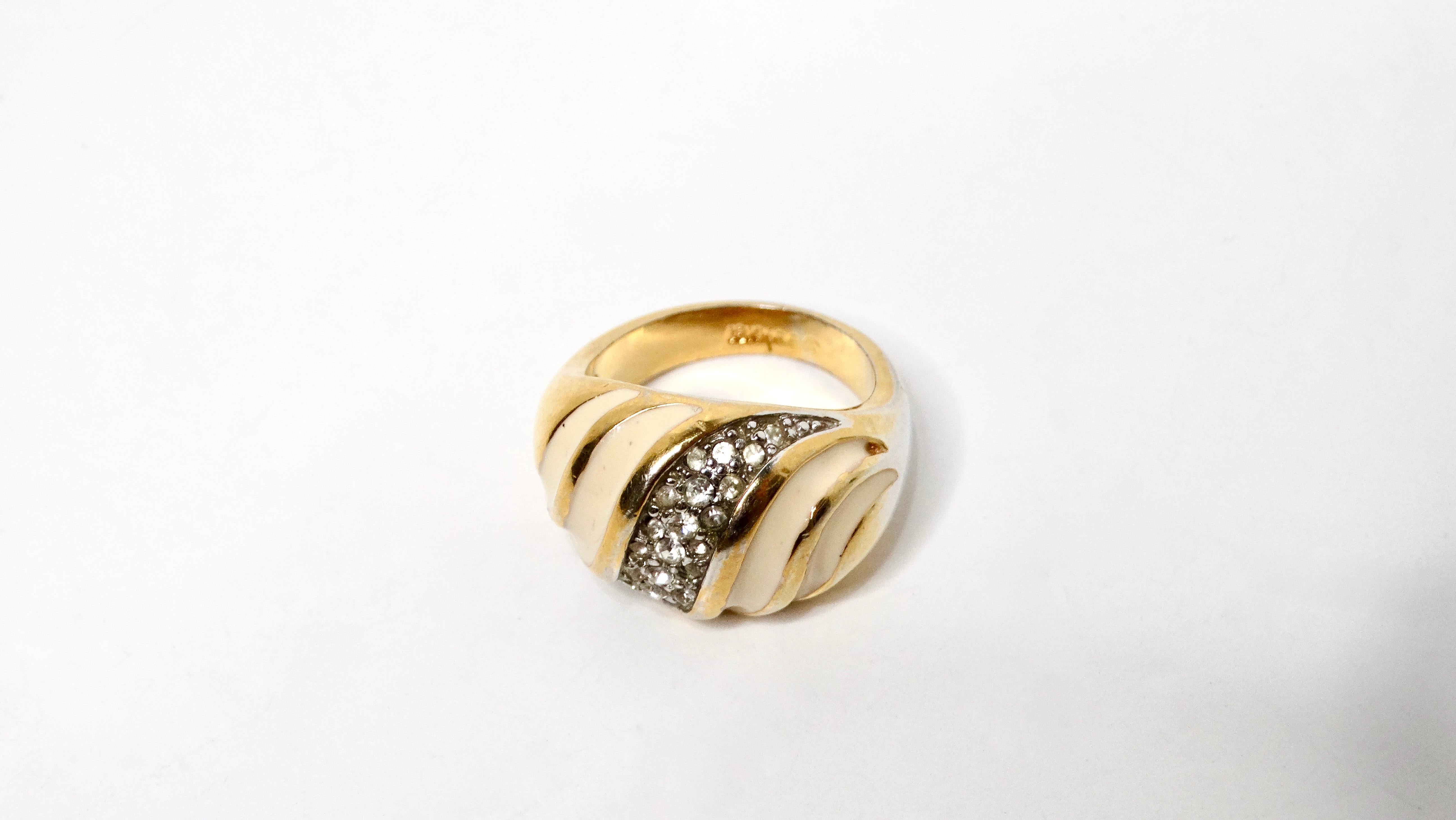 Step into a world of luxurious nostalgia with this Vintage 1970s 18k Gold Plated & Crystal Striped Dome Ring. This captivating piece features a stunning yellow gold-plated dome design that’s sure to catch the light and draw attention. The striped
