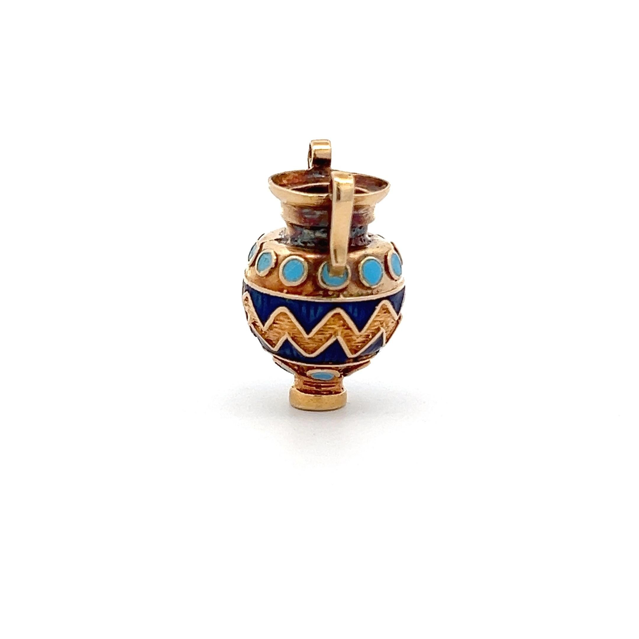 Ciondolo a forma di brocca d'acqua vintage degli anni '70, realizzato in oro giallo 18 carati con smalti blu. Ispirato all'antica anfora greca, il design è caratterizzato da doppi manici e da audaci motivi smaltati a zig zag e circolari, che gli