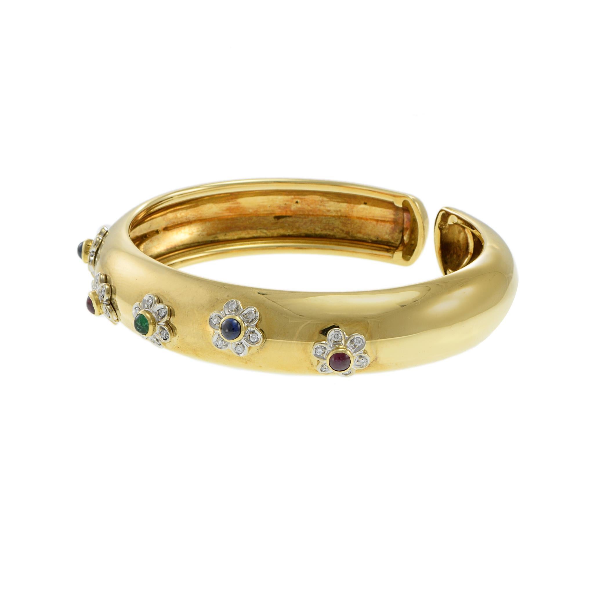 Vestige saisissant du design des années 1970, ce bracelet vintage associe des pierres précieuses cabochon vibrantes à un savoir-faire intemporel. Réalisé en or jaune 18 carats, il présente des motifs floraux ornés de rubis, de saphirs, d'émeraudes