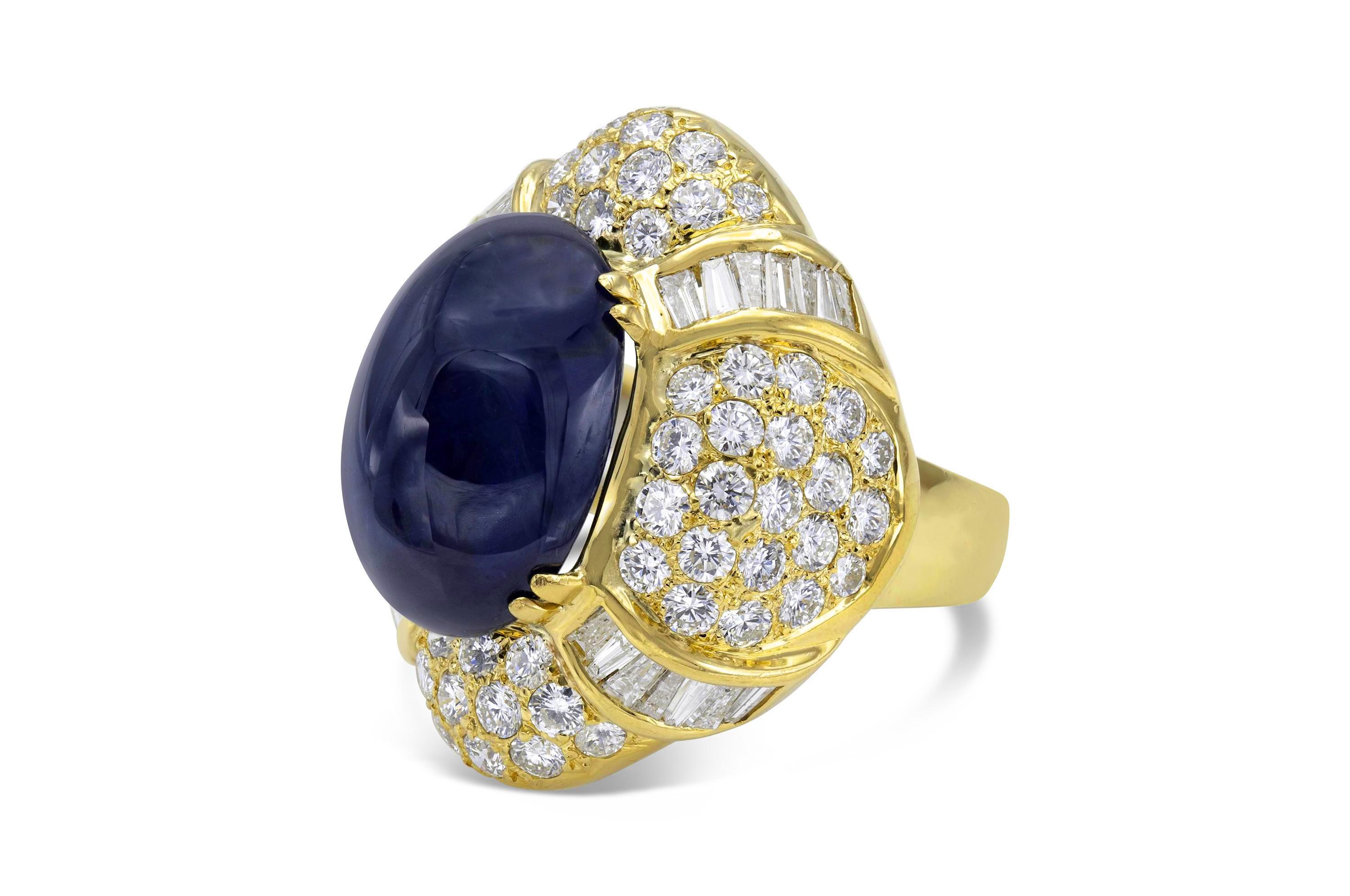 Finamente elaborada en oro amarillo de 18 quilates con un zafiro cabujón certificado por la AGTA que pesa 22,79 quilates.
El anillo tiene diamantes talla baguette y talla redonda brillante engastados en pavé, con un peso total aproximado de 7,00