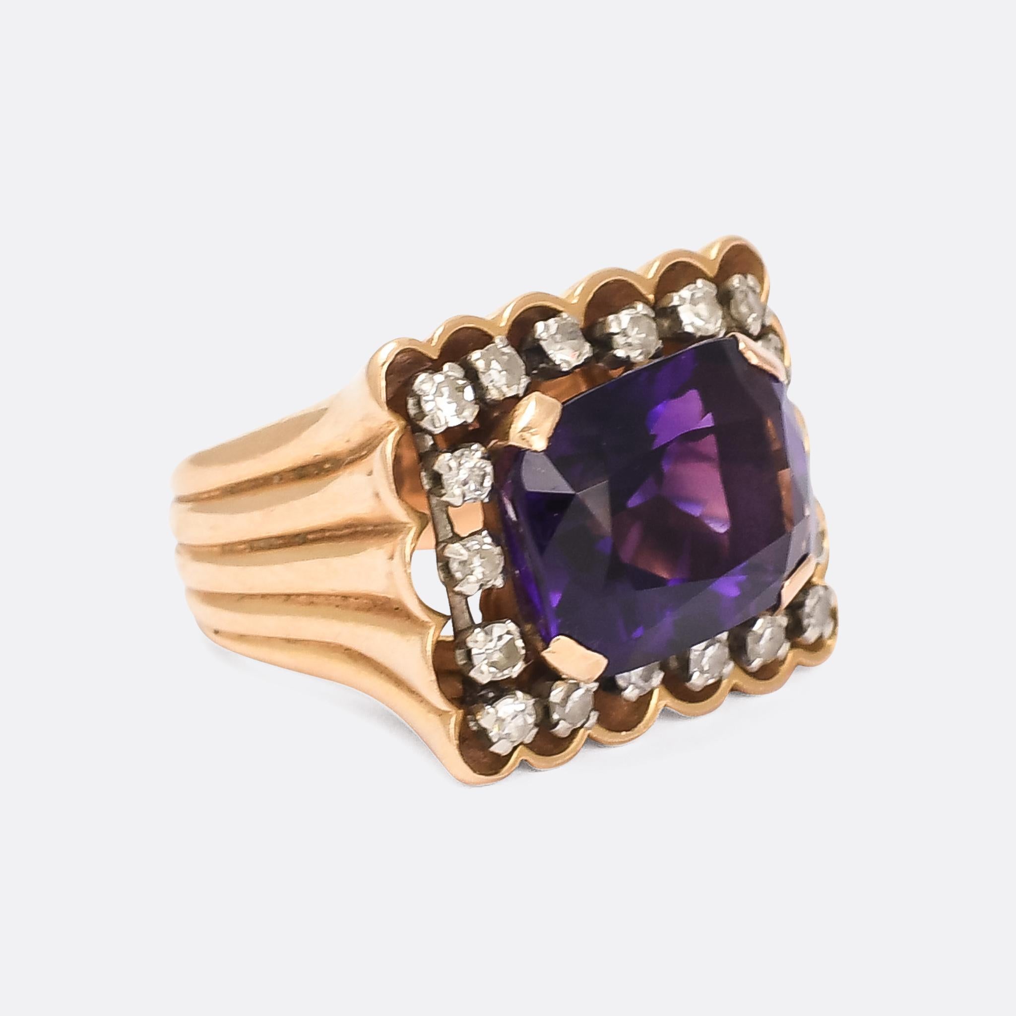A cool vintage siberian amethyst and diamond statement ring dating from the 1970s. The central cushion cut stone weighs 6.8 carats, and is surrounded by a border of single cut diamonds. Crafted in 18 karat gold throughout and particularly good