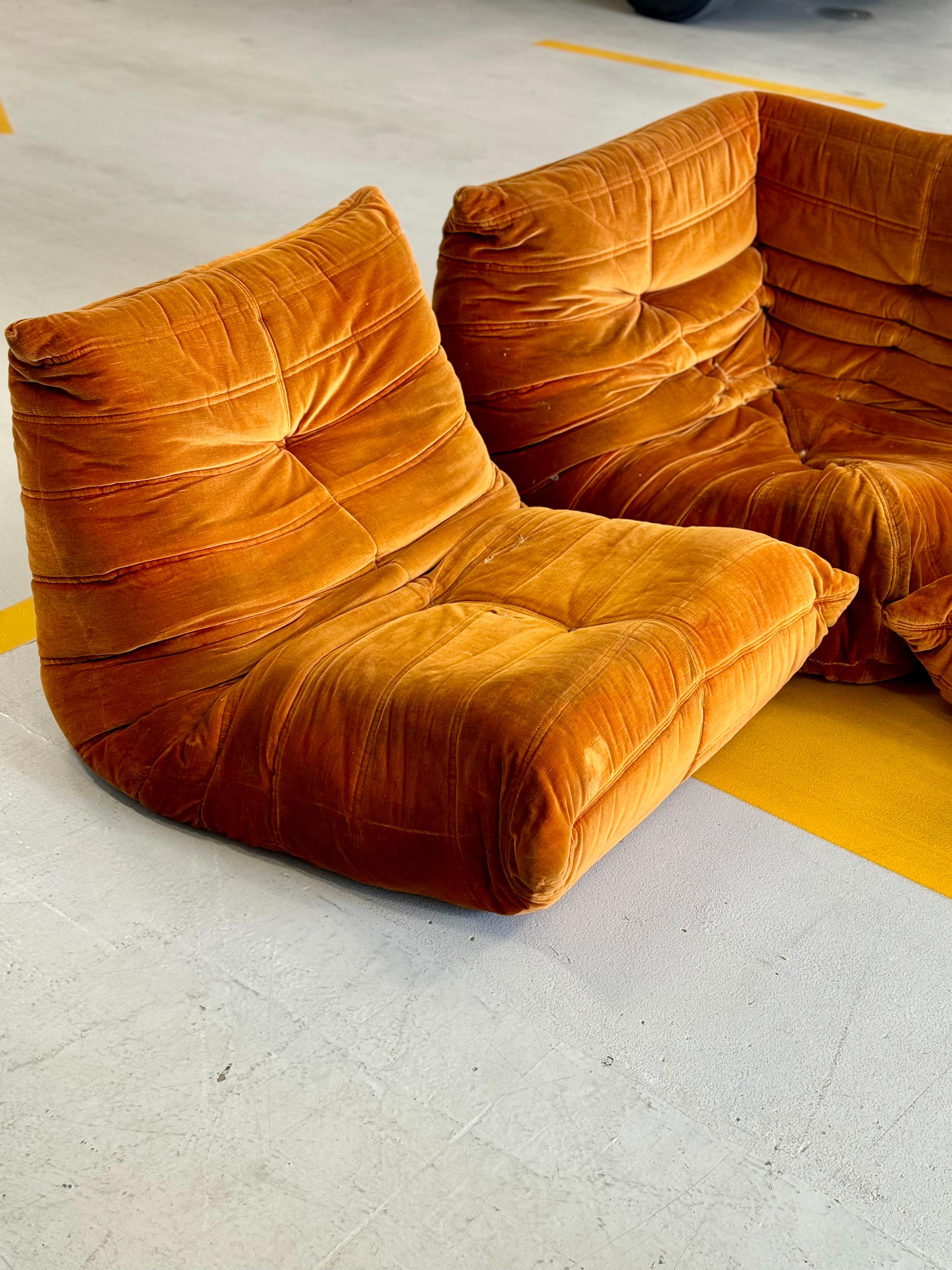 Vibrant vintage velvet Togo set. Original sunset orange upholstery. One of the harder colours to come by. A lesser-seen 1970’s set manufactured under licence of Ligne Roset of France by Arconas Canada for a few short years. 

The set is in worn