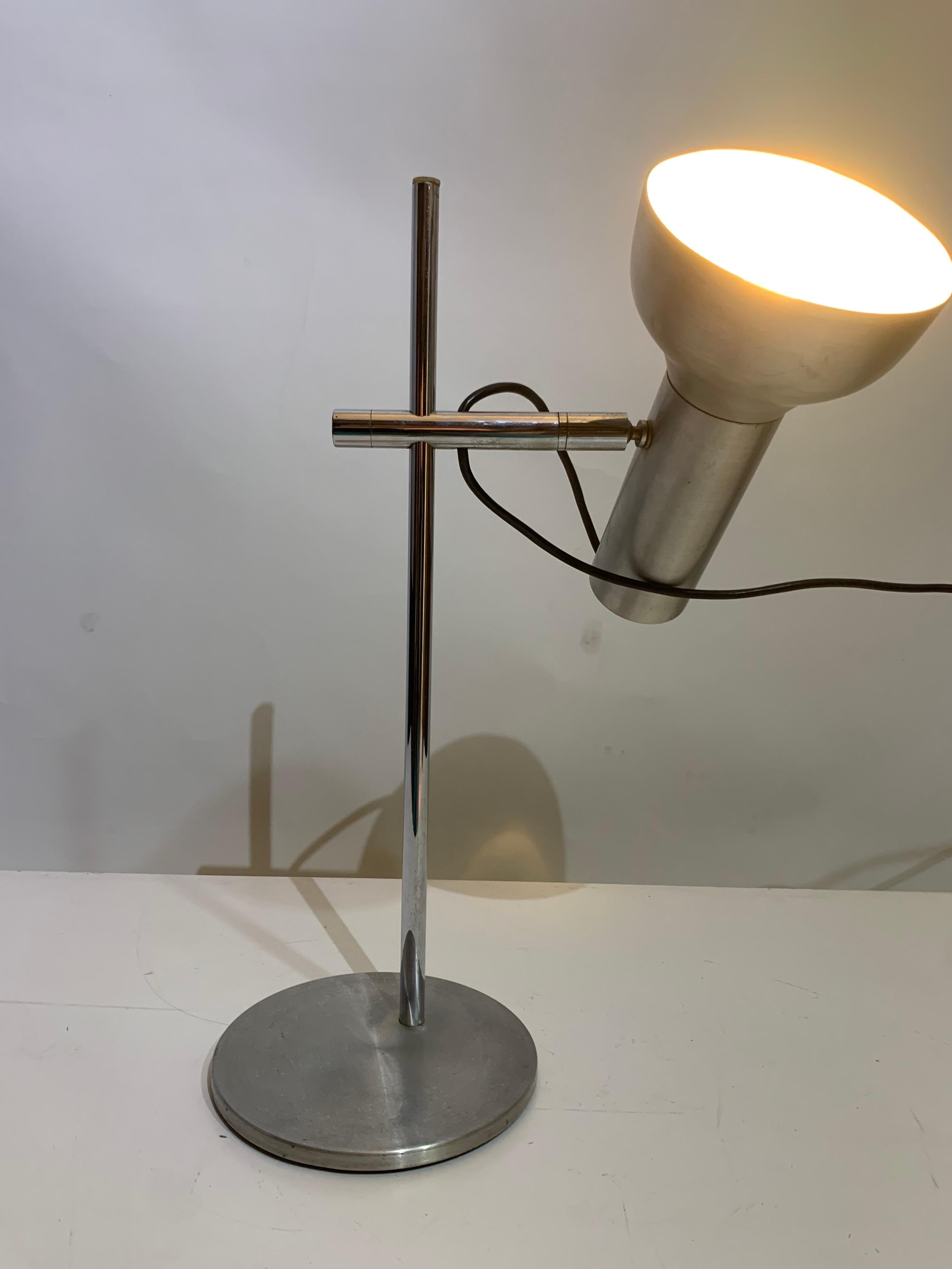 Desk lamp with adjustable height and all directions ( 360 degrees) tilt-able lampshade. Material is brushed and chrome-plated steel. The cantilevered metal is intersecting with the horizontal piece and is adjustable in height, allowing various