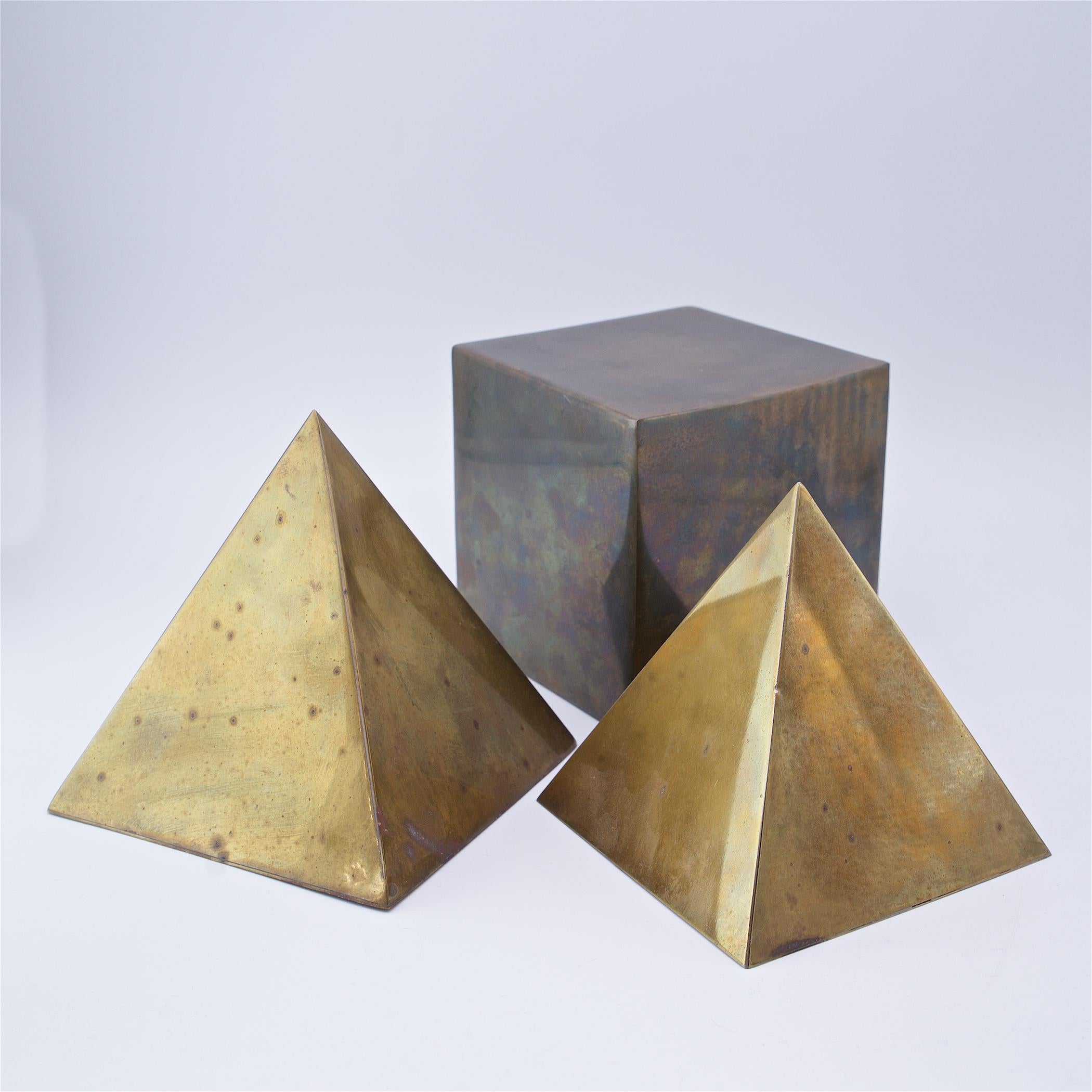 Sarreid Ltd. marked brass abstract shapes, Italy, circa 1970s. 

Sm pyramid W: 5 1/4 X D: 5 1/4 X H: 5 1/4 in.
Md pyramid W: 5 5/8 X D: 5 5/8 X H: 6 in.
Cube W: 5 1/4 X D: 5 1/4 X H: 5 1/4 in.

Showing wear, heavy patina to brass, this could
