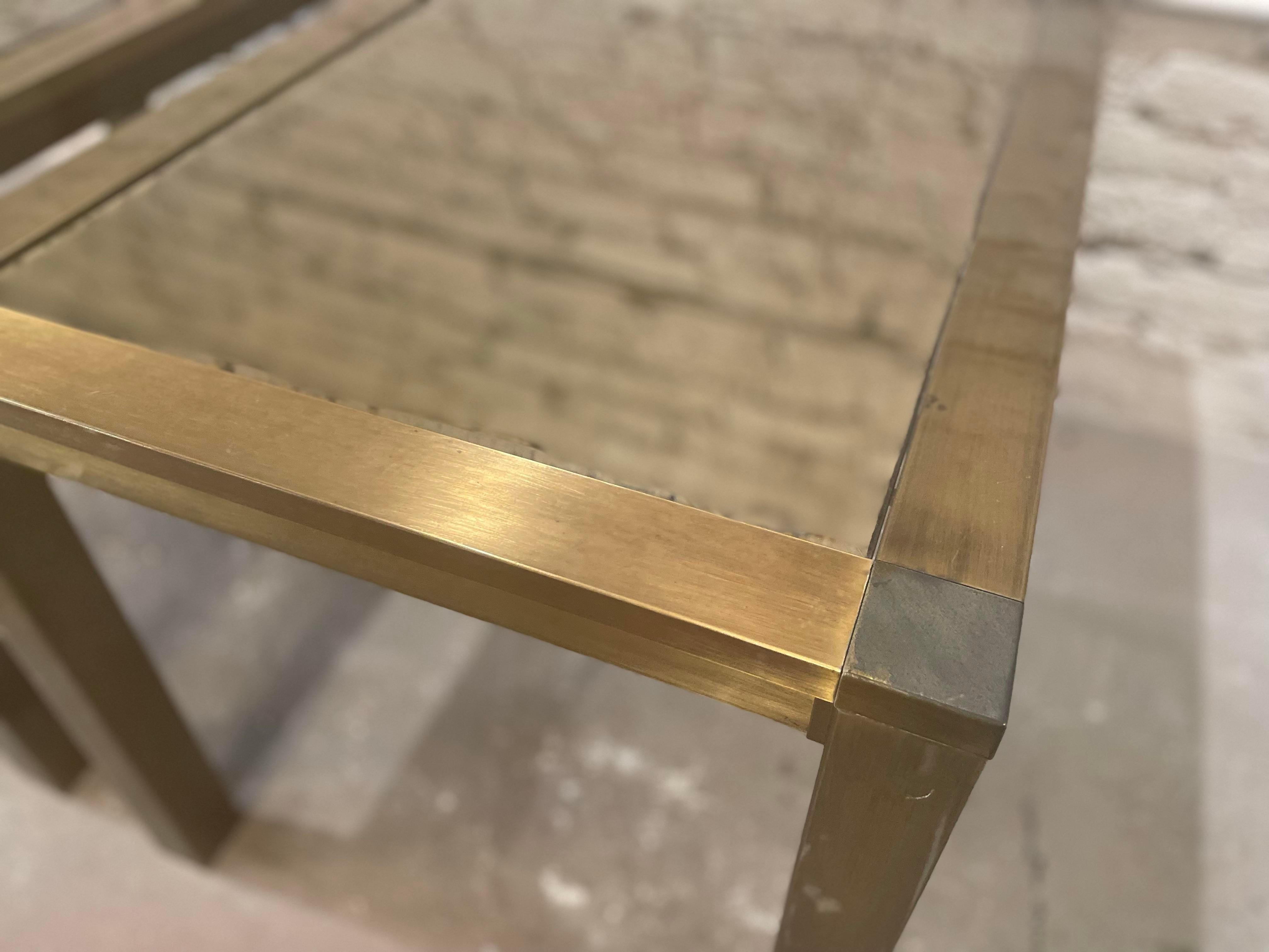 Beautiful vintage pair of brushed brass side tables with mirrored glass top. These are in wonderful condition. Sturdy and chic.

DIMENSIONS: 30ʺW × 21.5ʺD × 21ʺH
STYLES: Art Deco, Hollywood Regency, Mid-Century Modern
TABLE SHAPE: Rectangle
PERIOD: