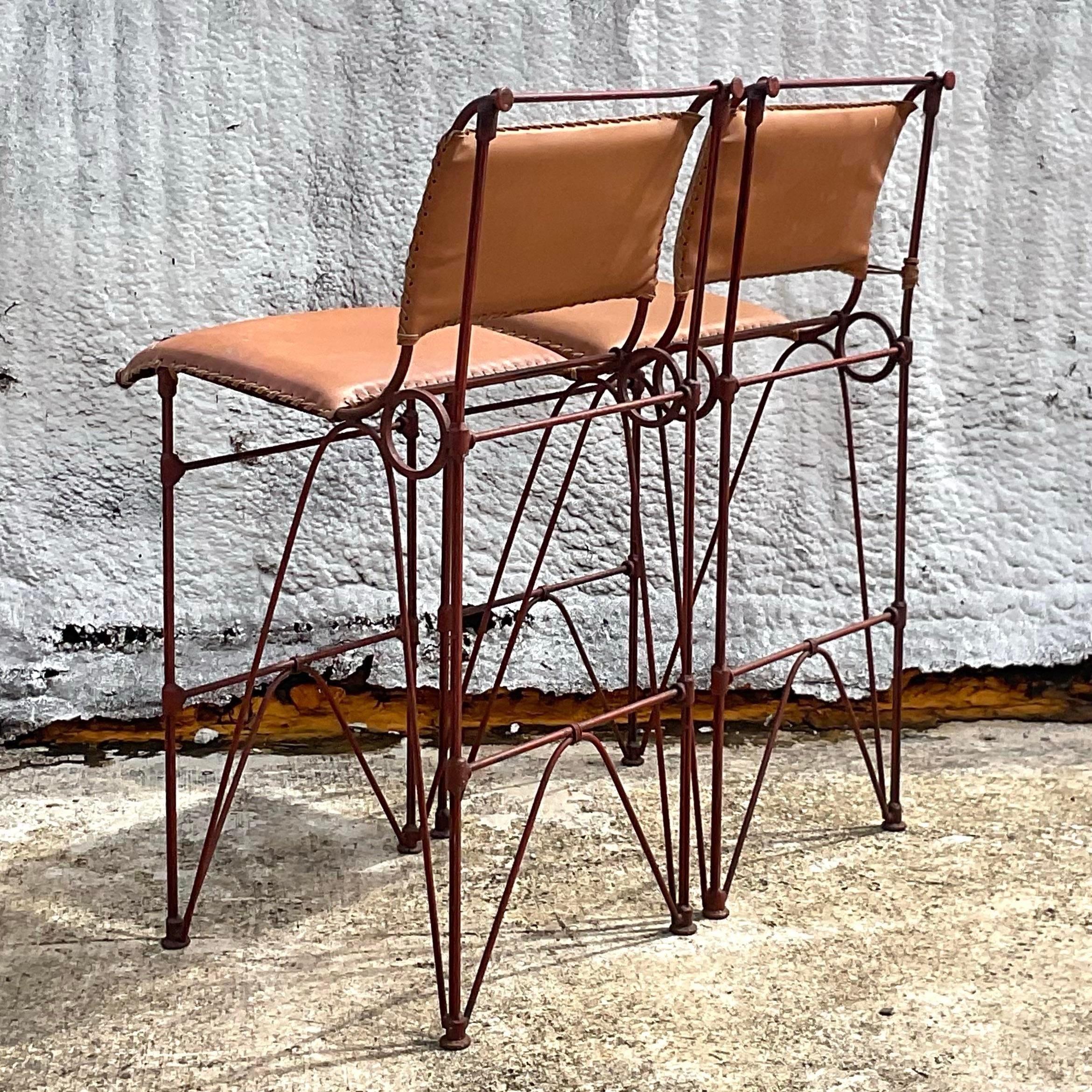 A fabulous pair of vintage bar stool done in the manner of Ilana Goor. The bar stools are in a brutalist style with bent rebar and leather seating. Acquired at a Palm Beach estate.