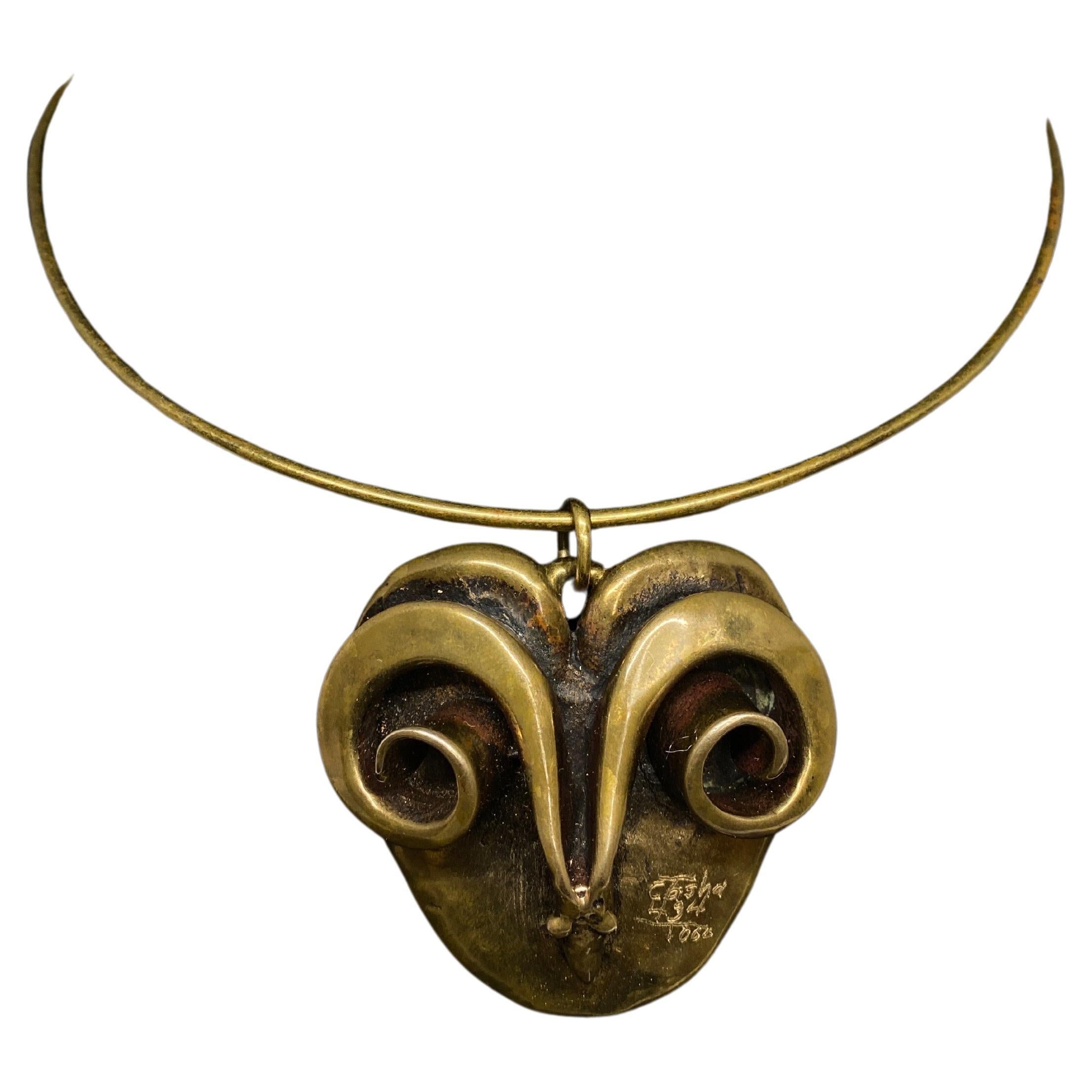 Up for your consideration is this rare necklace by Carl Tasha. He was a well known artist from United States that was a pioneer in the Brutalist Movement in the 1960’s and ‘70’s. 

A capitavating modernist ram head sits at the center of a wire
