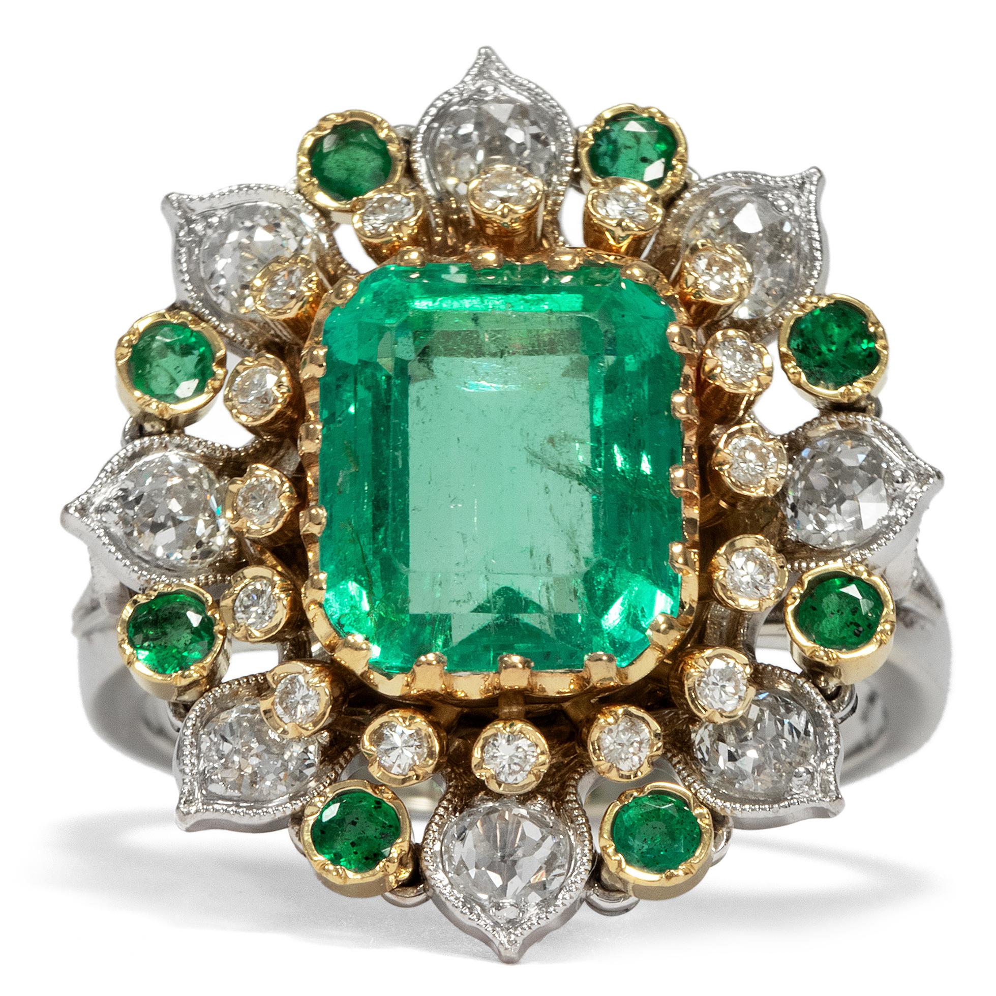 This spectacular vintage ring, dating to circa 1970, presents an excellent emerald of 3.5 ct weight in its centre. The gemstone is cut in the classic step cut, also known as emerald cut, and shows an intense green colour and beautiful transparency.