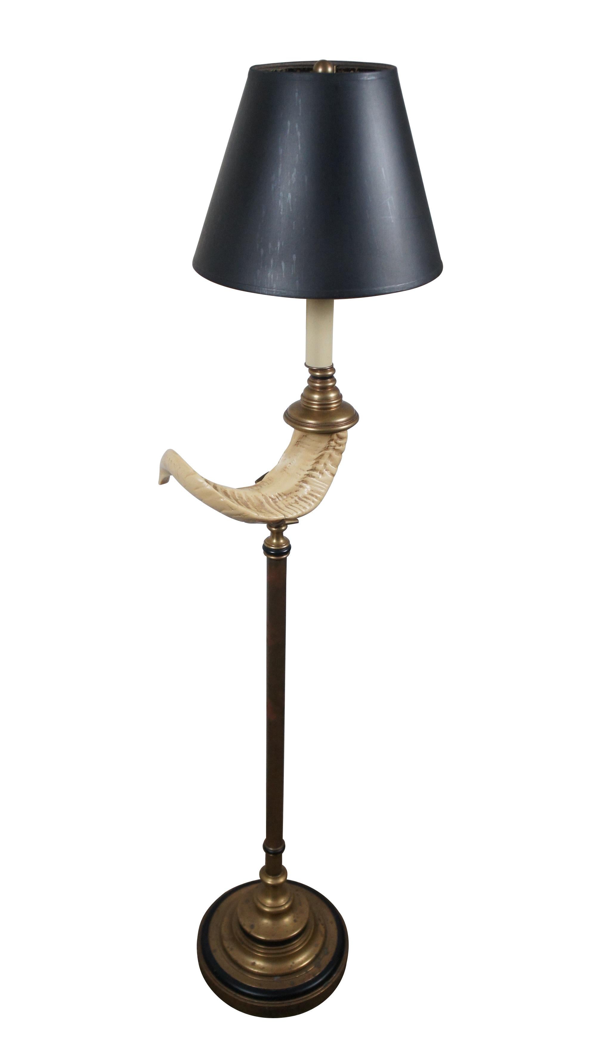 Circa 1970's Chapman Brass floor lamp featuring a round, stepped pedestal base and artificial ram's horn perched on the column body with black accents, leading to a faux candlestick top. Black paper shade with foiled interior. Includes harp and ball