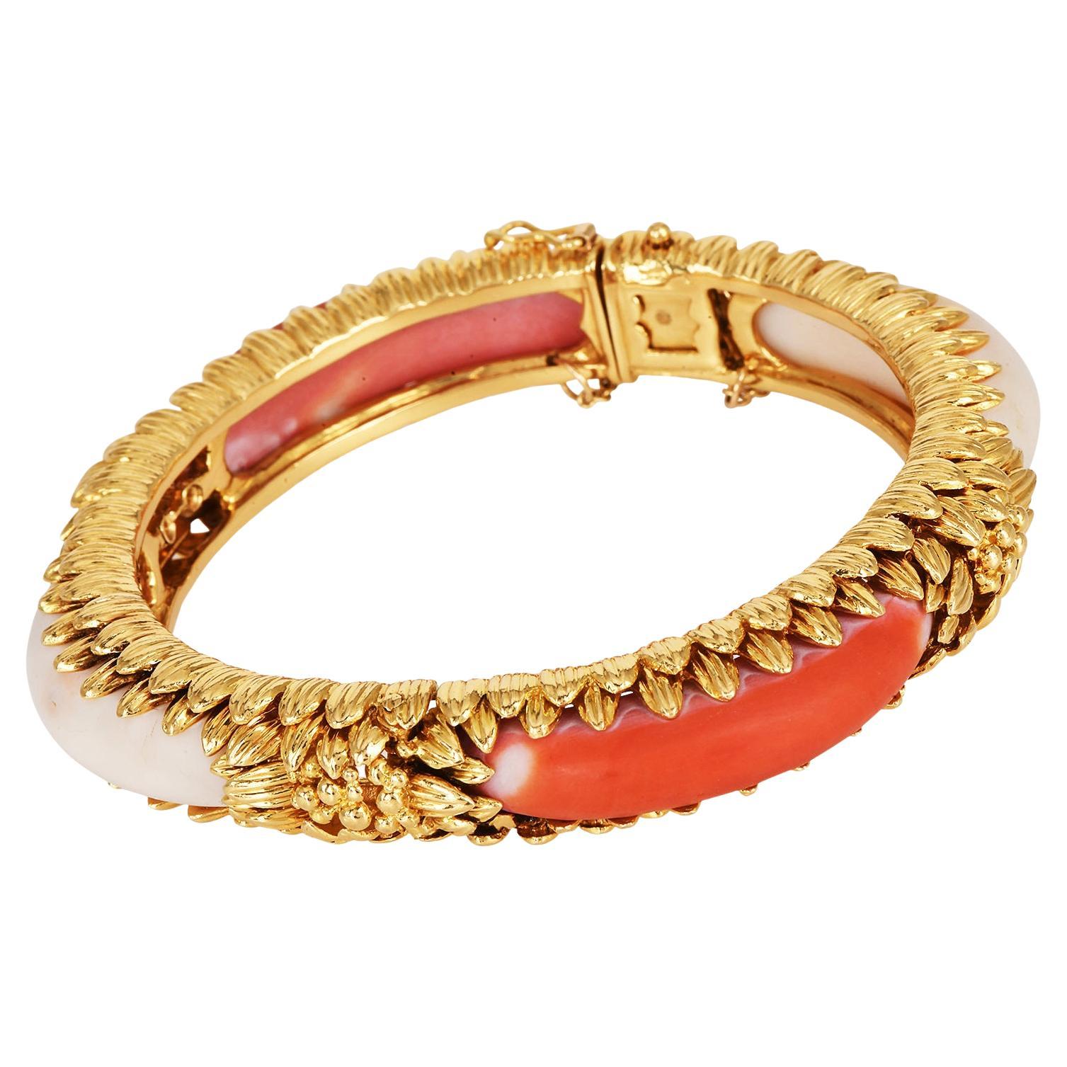 Dieses schicke Armband aus den 1970er Jahren ist aus 18 Karat Gelbgold gefertigt,

Dieser Vintage-Armreif ist sehr feminin und trendig. Er ist schick, besetzt mit zwei lachsfarbenen Naturkorallen und zwei weißen Naturkorallen.

Abmessungen: 7 Zoll (