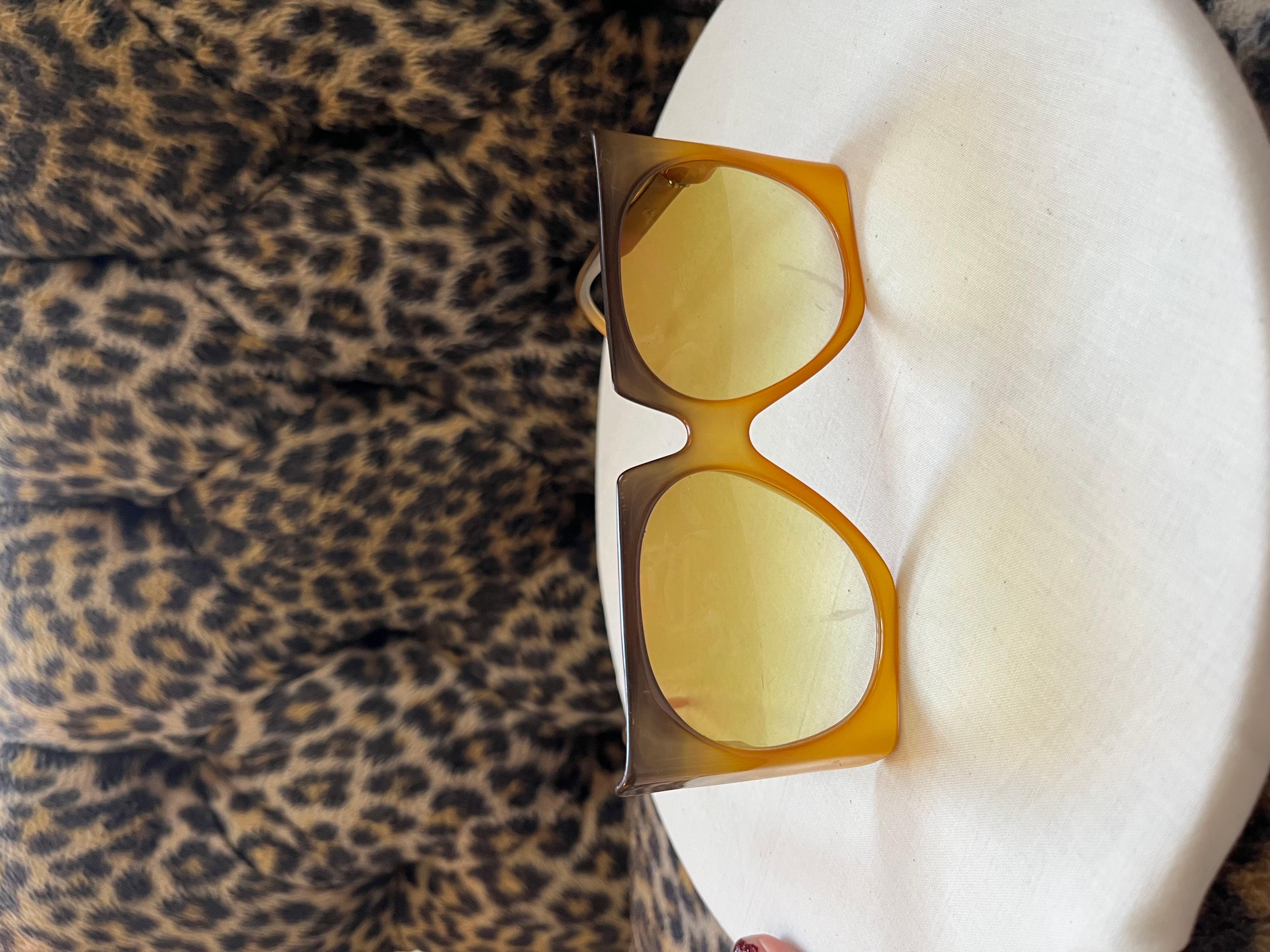 Vintage 1970s Christian Dior Oversize Square Sunglasses 

These awesome exaggerated square space-age style sunglasses from the 1970's are made in Austria, with silver CD Logo on the side. They are a brown to amber gradient with oval amber lenses.